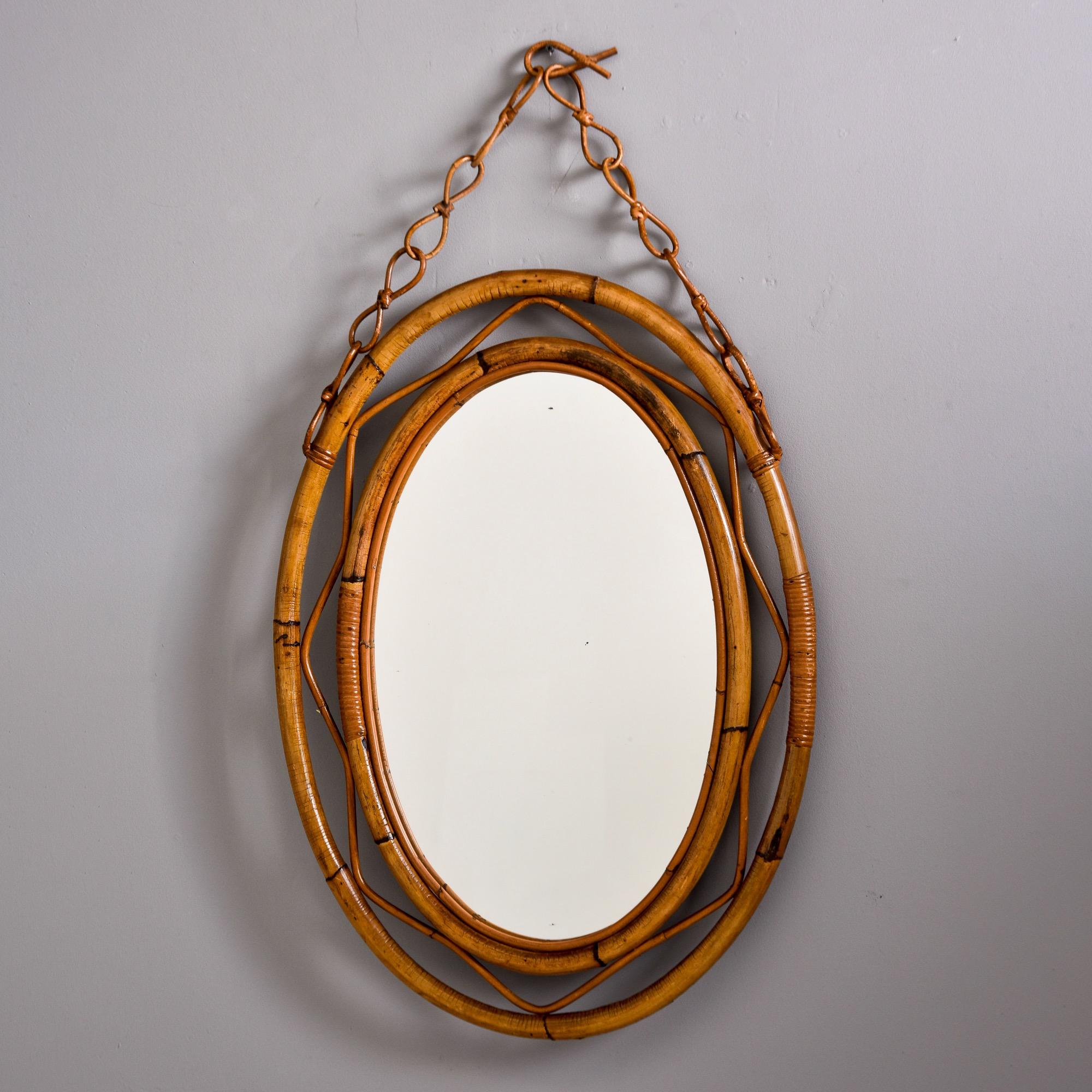 Found in Italy, this hanging oval mirror with rattan frame dates from the 1970s. Unknown maker - oval mirror with double rattan frame and hanging rattan chain. Very good vintage condition with no flaws found - minor expected wear only.

Height With