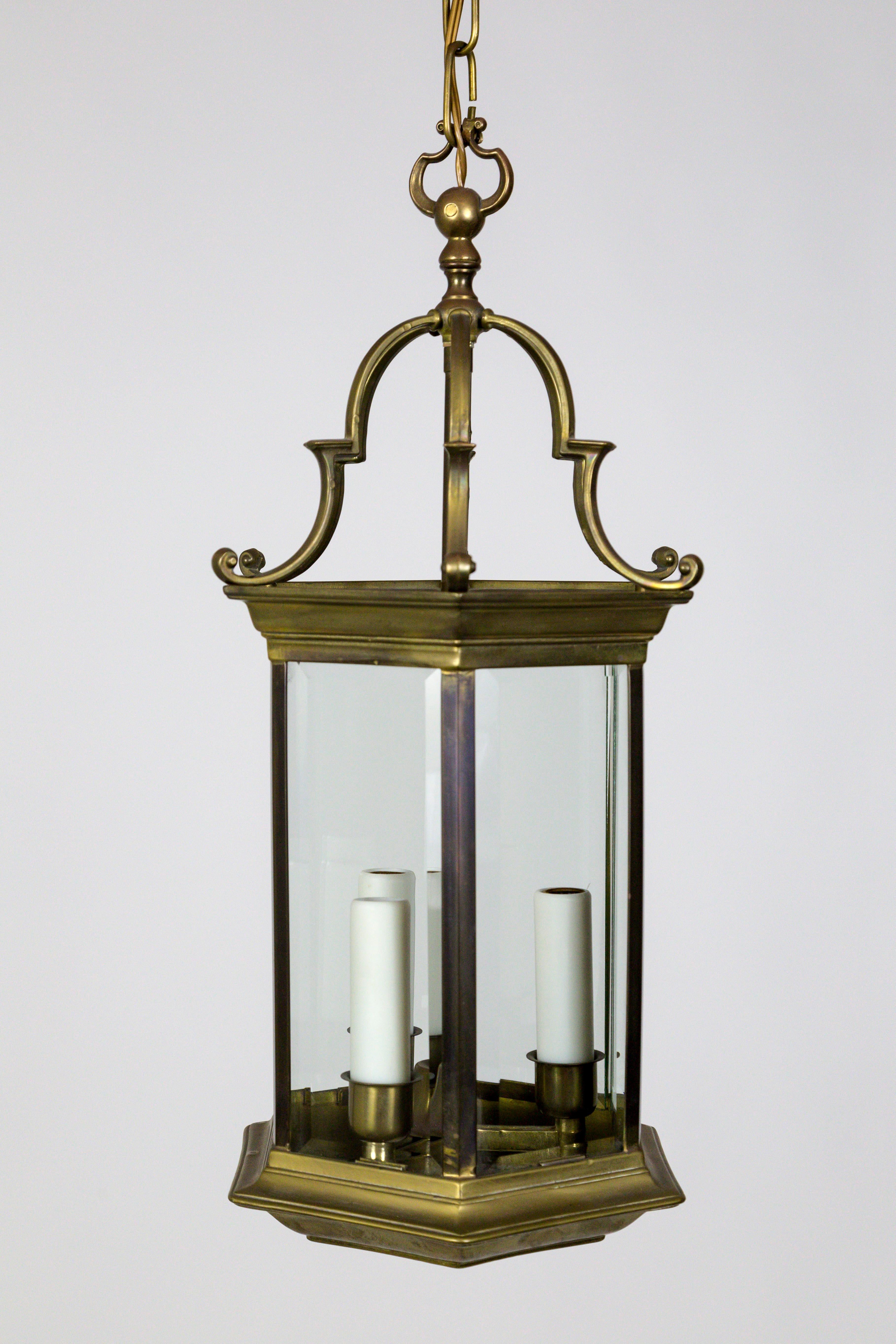 An Italian, neoclassical, 6-sided lantern with thick, beveled glass. Composed of heavy bronze and brass, with pagoda-esque details, and three candlesticks with poly-beeswax candle covers, circa 1950s. Measures: 9
