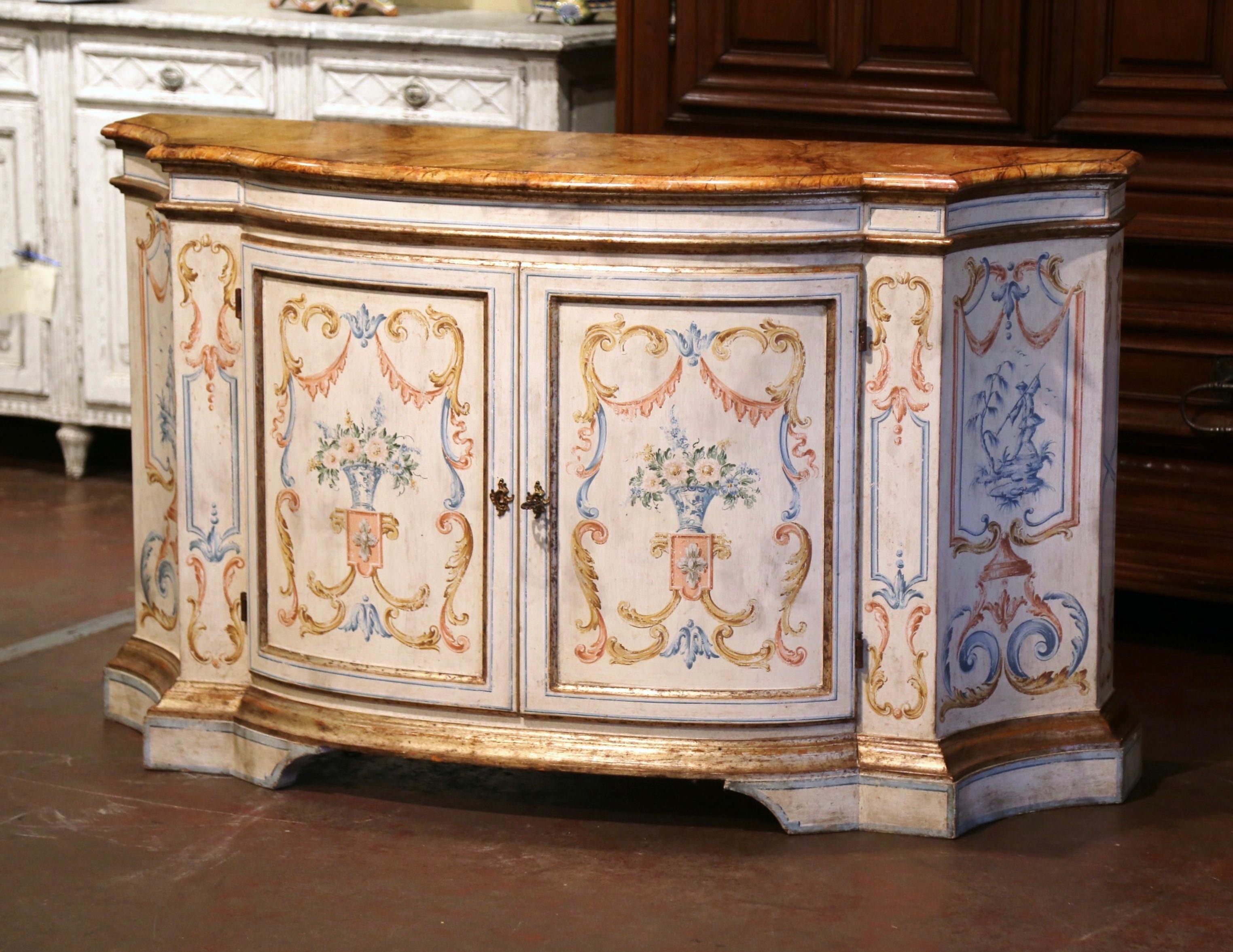 Created in Italy circa 1960, the colorful buffet stands on bracket plinth. The antique cabinet features two bombe doors on the front opening to shelving and inside lighting, and elegant in-curved sides. Both sides and facade are decorated with hand