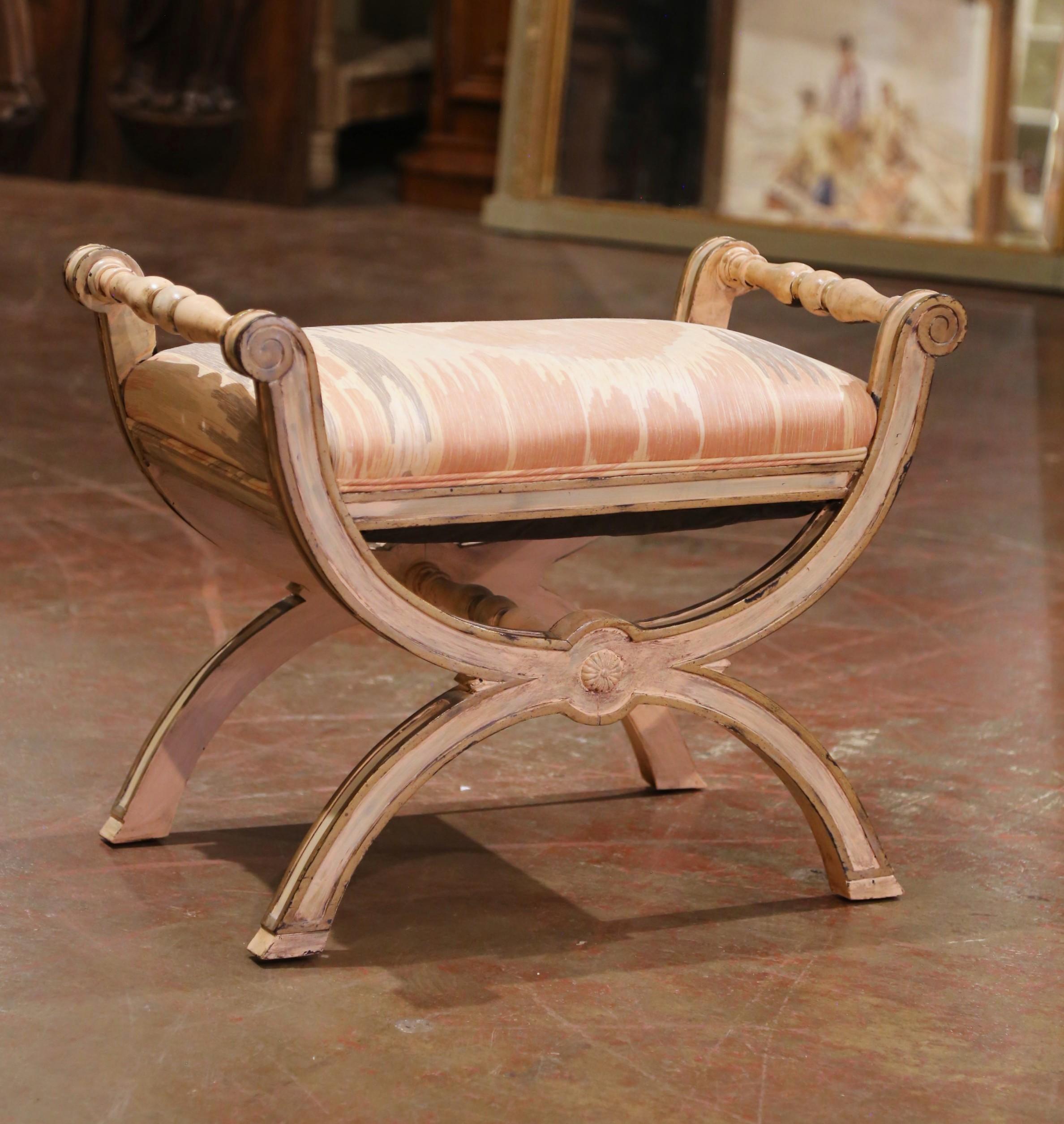 Ce tabouret curule italien du milieu du siècle, fabriqué vers 1960, présente une base en X gracieusement arquée avec des extrémités en volute et des poignées latérales tournées. Le cadre en bois de hêtre sculpté à la main est recouvert d'une