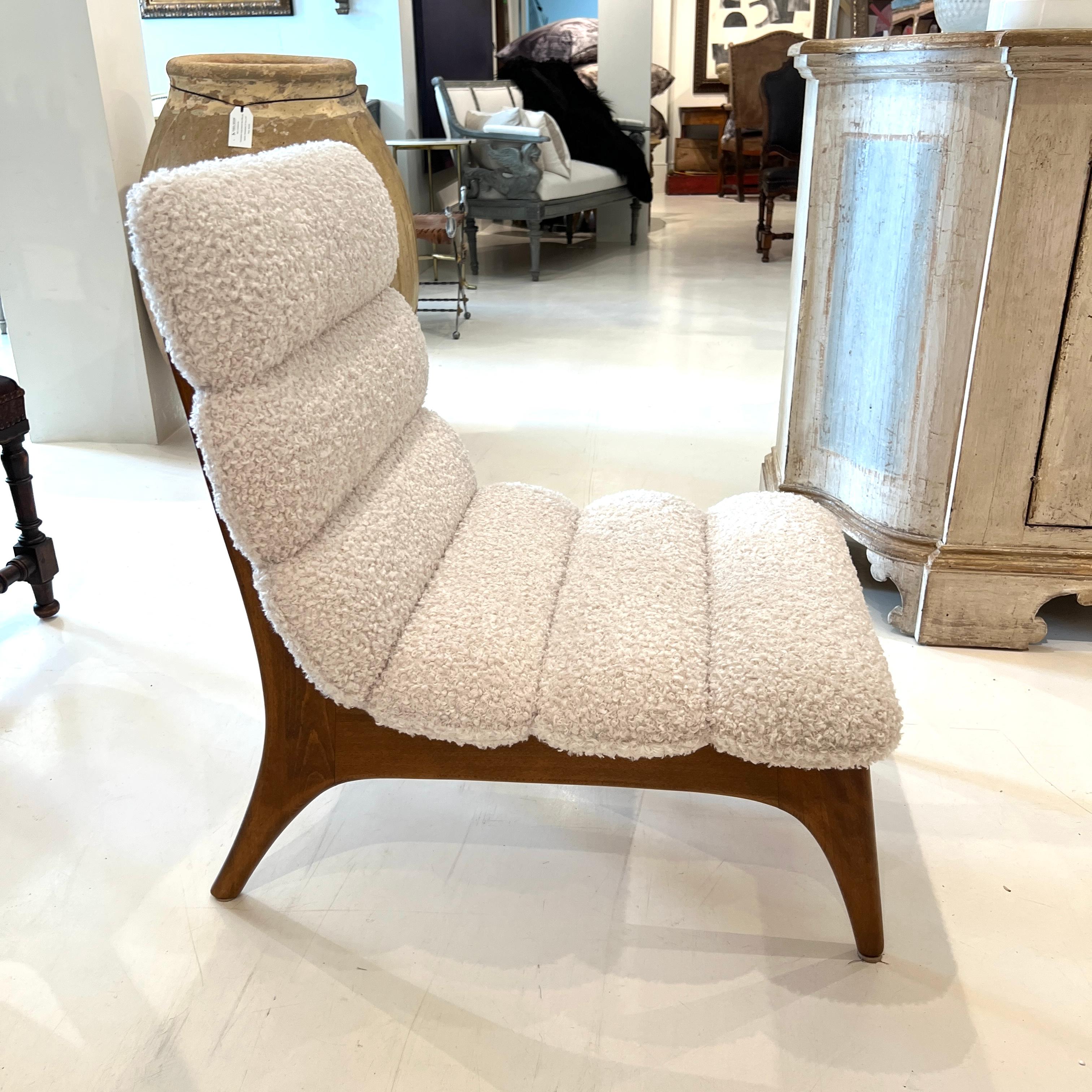 Un refinado par de sillas italianas de mediados de siglo fabricadas en madera de fresno, con líneas limpias y esculturales, y tapizadas en bouclé cremoso para conseguir un cálido contraste de texturas que combina la elegancia atemporal con la