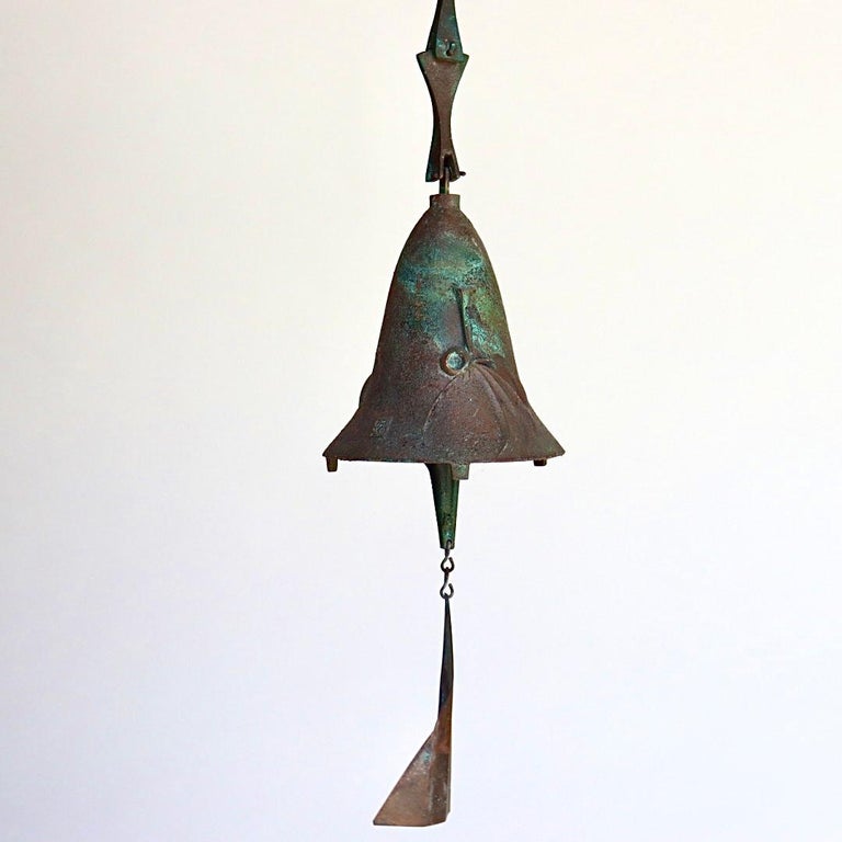 Medium size patinated bronze wind bell sculpture by Paolo Soleri (Italy, later America; 1919-2014). Beautiful, substantial Mid Century wind chime bell, original kite, visually striking verdigris patina. Signed, embossed design. Circa 1960s. This