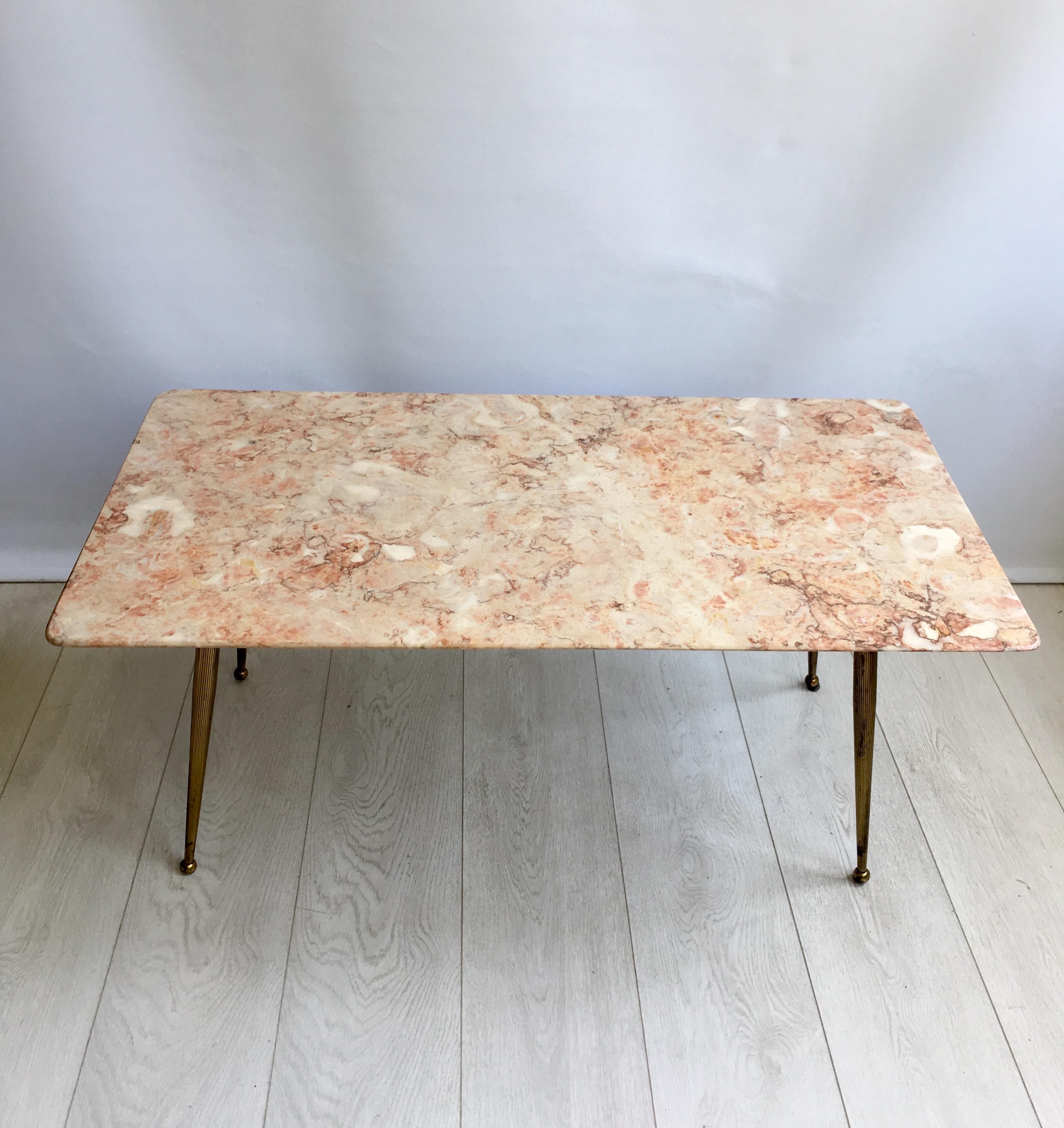 Beautiful coloring to this pink marble top coffee table.

Sitting on an aged gilt metal base with attractive ribbed legs and ball feet. 

One small nick to one side but not very noticeable (please see close up image).
    