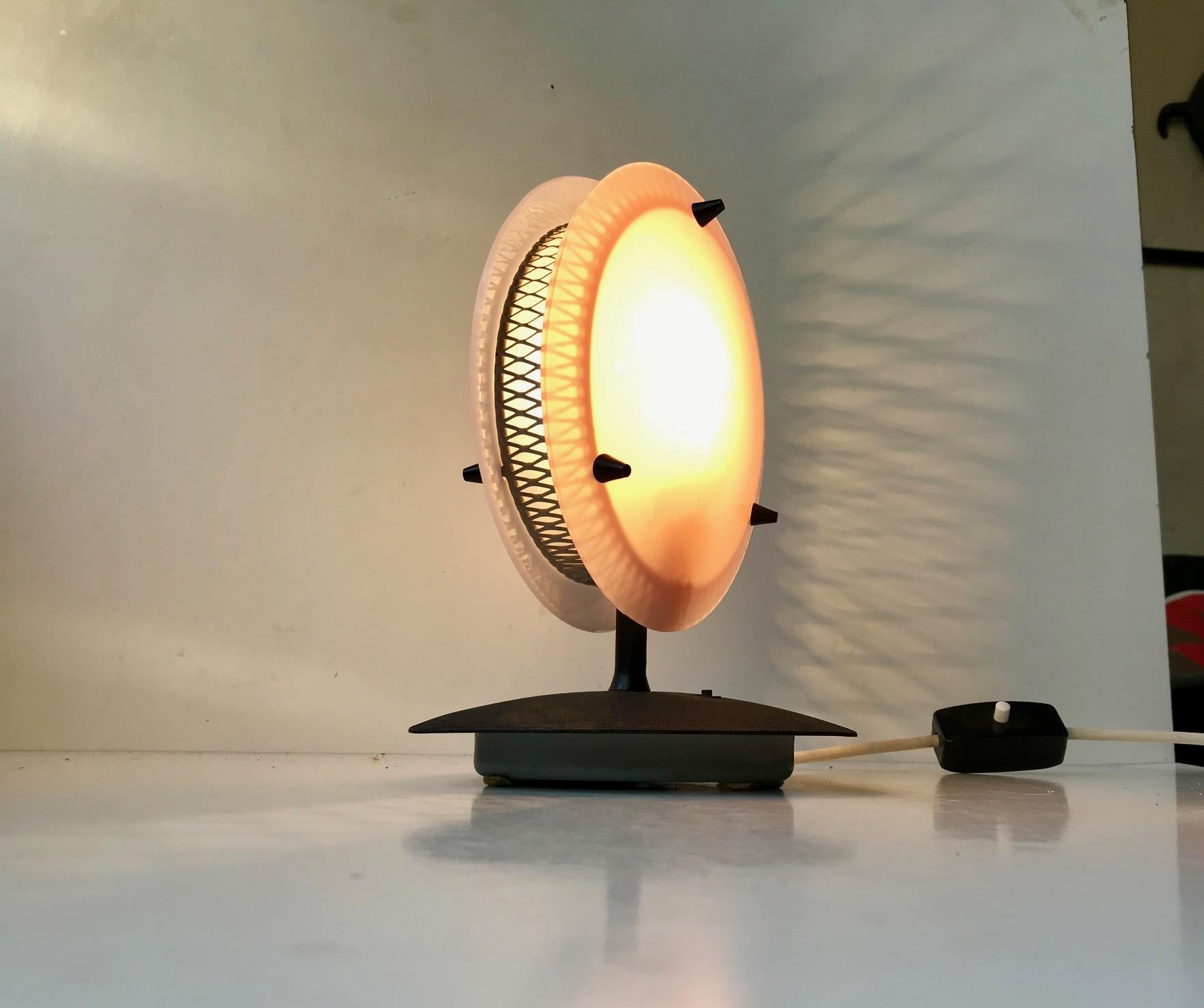 Unusual table light composed of two Lucite shades. One pink and one white separated by patterned metal mesh. The base is made from lacquered metal. Anonymous Italian maker or designer, circa 1960 in the style of Jacques Biny and Pierre Gauriche.