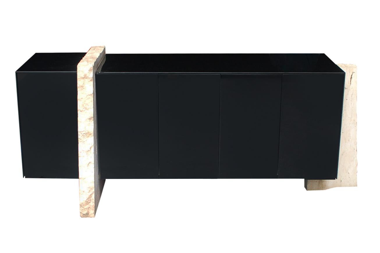A chic modernist design that was produced in Italy in the 1980's. It features a glossy black cabinet, two heavy travertine legs, and a blush pink interior.