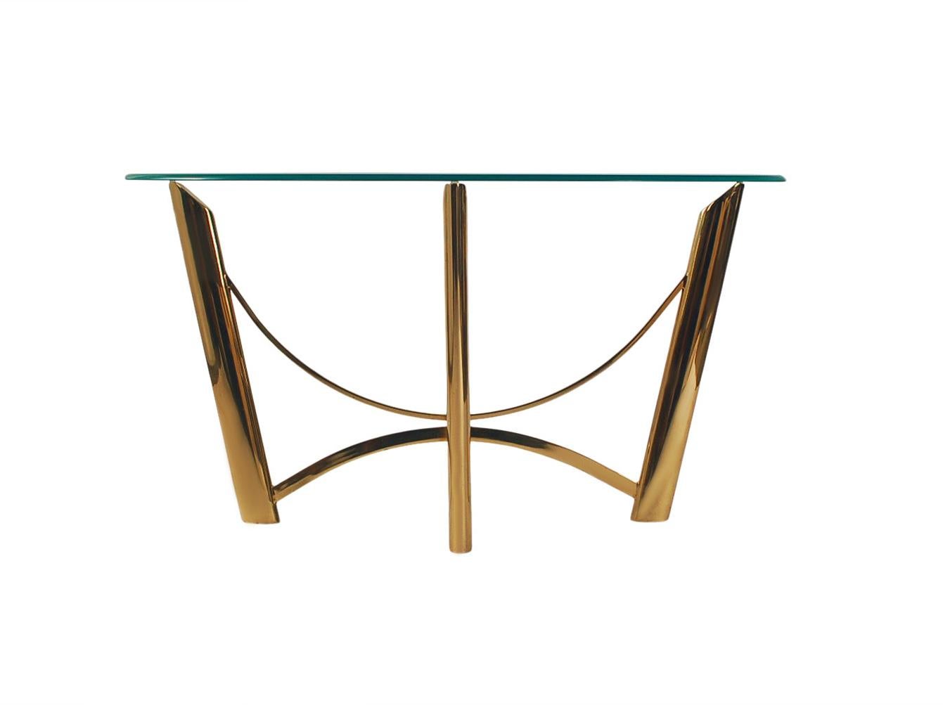 A sharp line demilune console table or sofa table from Italy circa 1980's. It features a mirror polished brass frame with clear glass top.