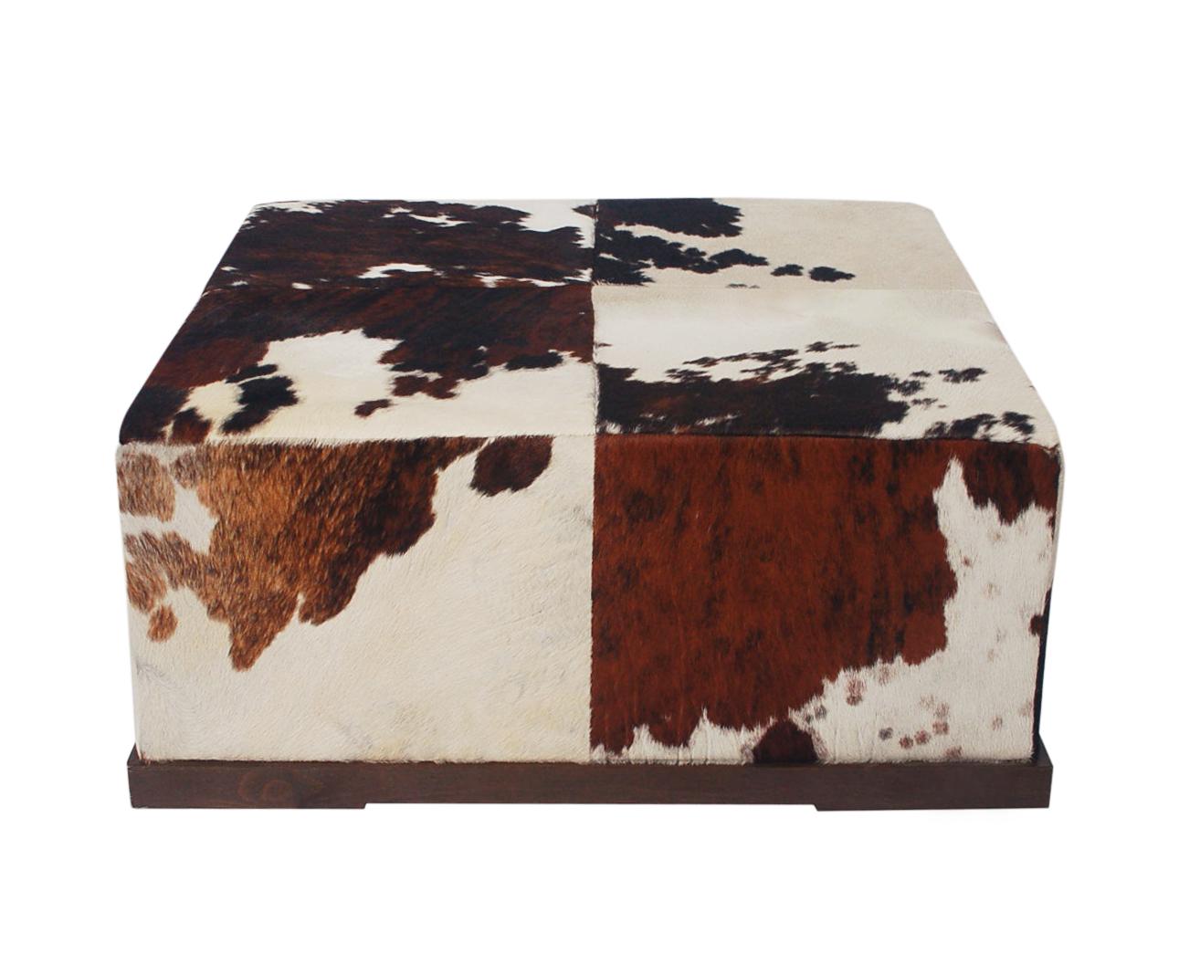 A gorgeous 1990's cowhide oversized ottoman made in Italy by Natuzzi. It features walnut base with beautifully patterned cowhide. Very good condition.