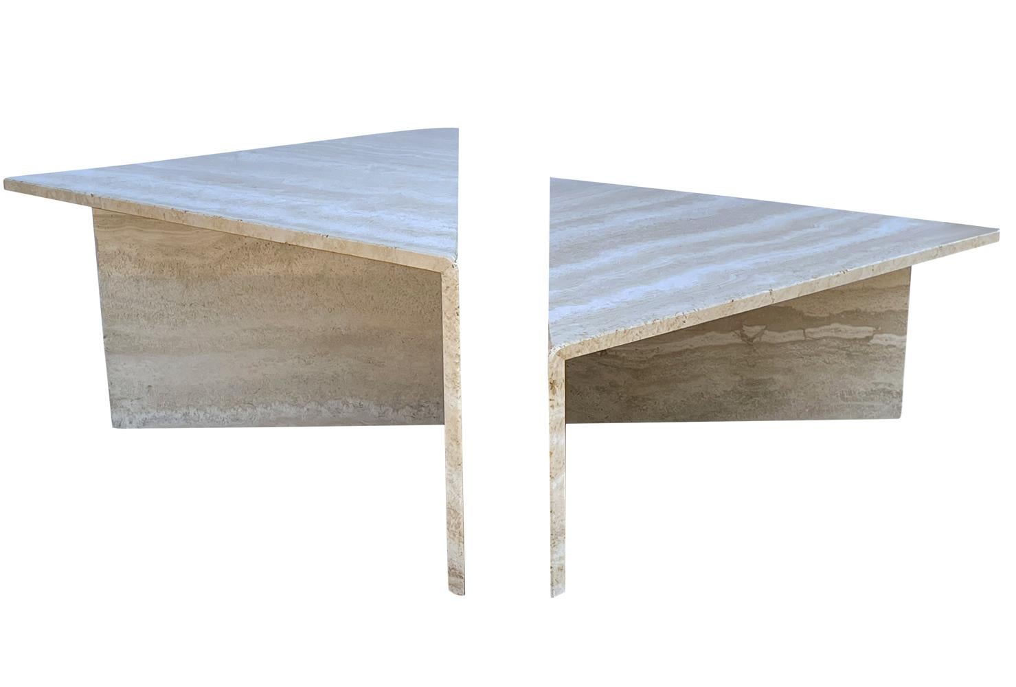 Two piece contemporary design circa 1990s from Italy. Solid travertine construction. Each table measures 55 inches from corner to corner. 27.5 inches wide. The taller table is 16 inches tall and the shorter table is 12 inches tall.