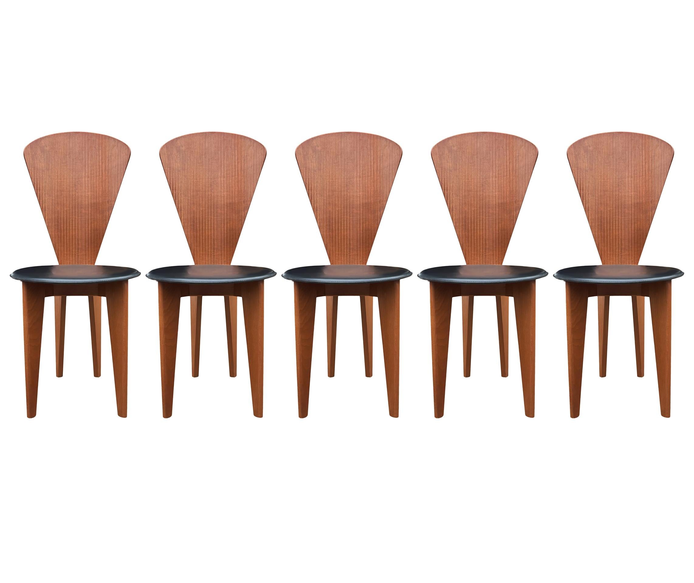 A set of five high back dining chairs from Italy. The feature sculpted ribbed wood backrests with black leather seats. Very striking design.