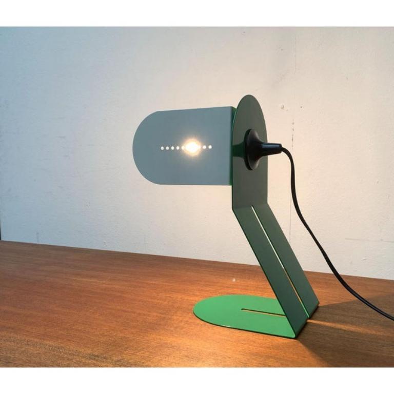 Italienische Tischleuchte mit postmoderner Designsprache und einer besonderen Farbgebung in Grün und Weiß. Design von boccato gigante zambusi architetti für Seccose.

ein postmodernes Design mit minimalistischer Konstruktion. Der Korpus der Lampe