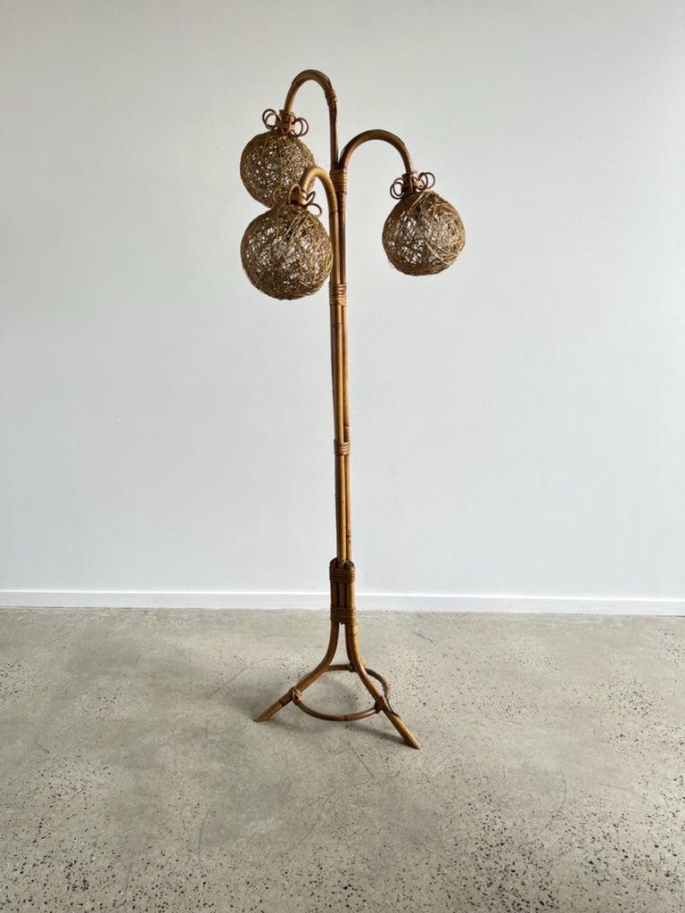 Lampadaire italien en bambou fait à la main avec trois boules en rotin, base tripode. 1960s.
Un objet design parfait pour embellir votre pièce !
 