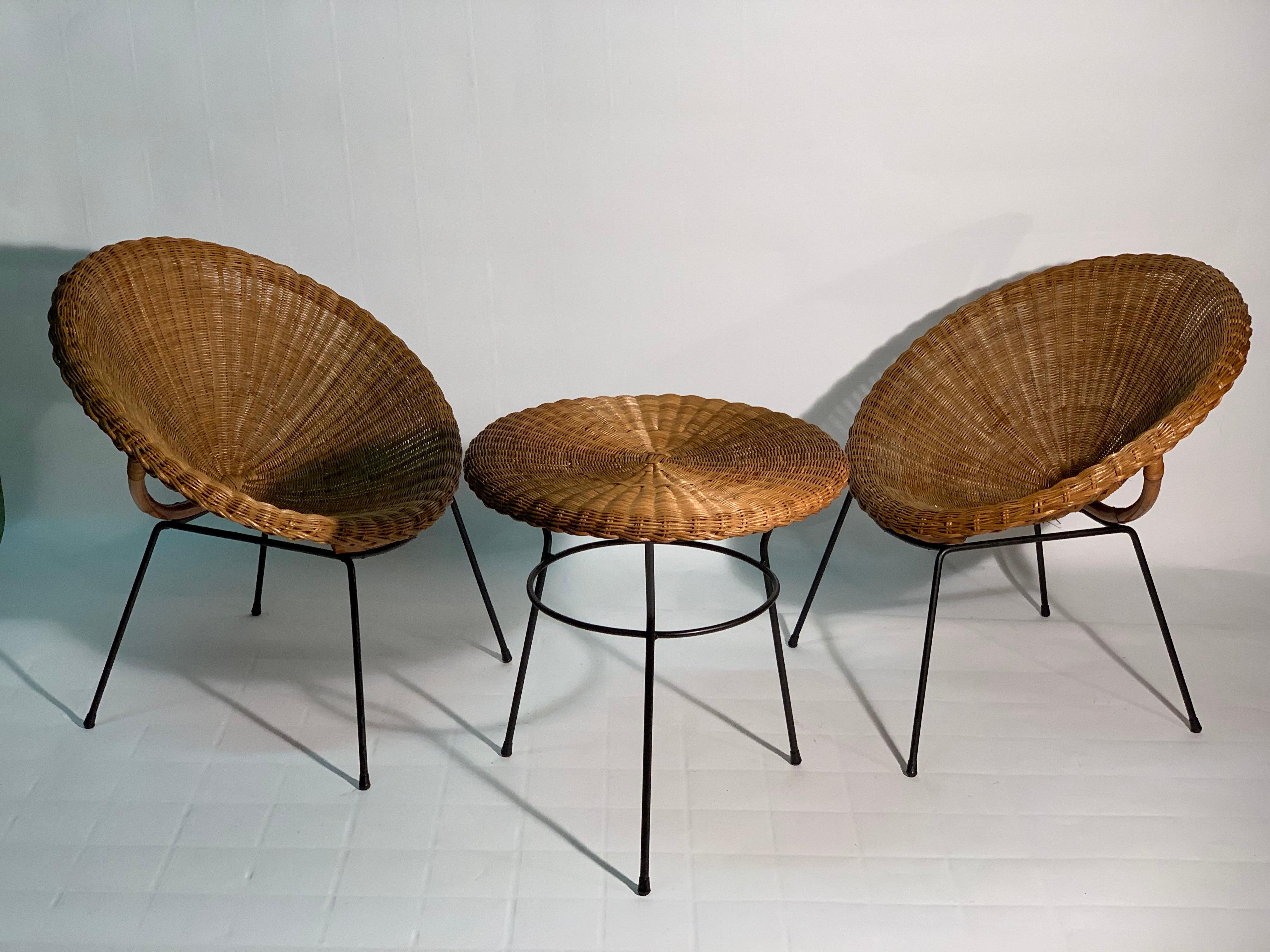 Two rattan and bamboo circular armchairs with black lacquered metal frame and feet. The armchairs are accompanied by a circular table also in rattan and feet in lacquered metal.
Italy Mid-Century Modern 1950
Measures of the table:
Height cm 58