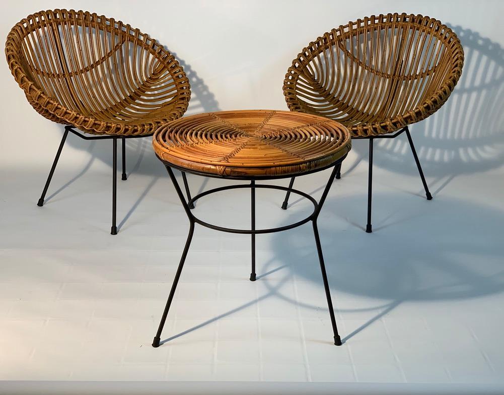 Set composed of two Italian midcentury armchairs in the shape of a nest and a round bamboo rattan coffee table or side table with legs in black lacquered metal.
Italy 1950s.
The listed measures are about the armchairs .
The measures table
height