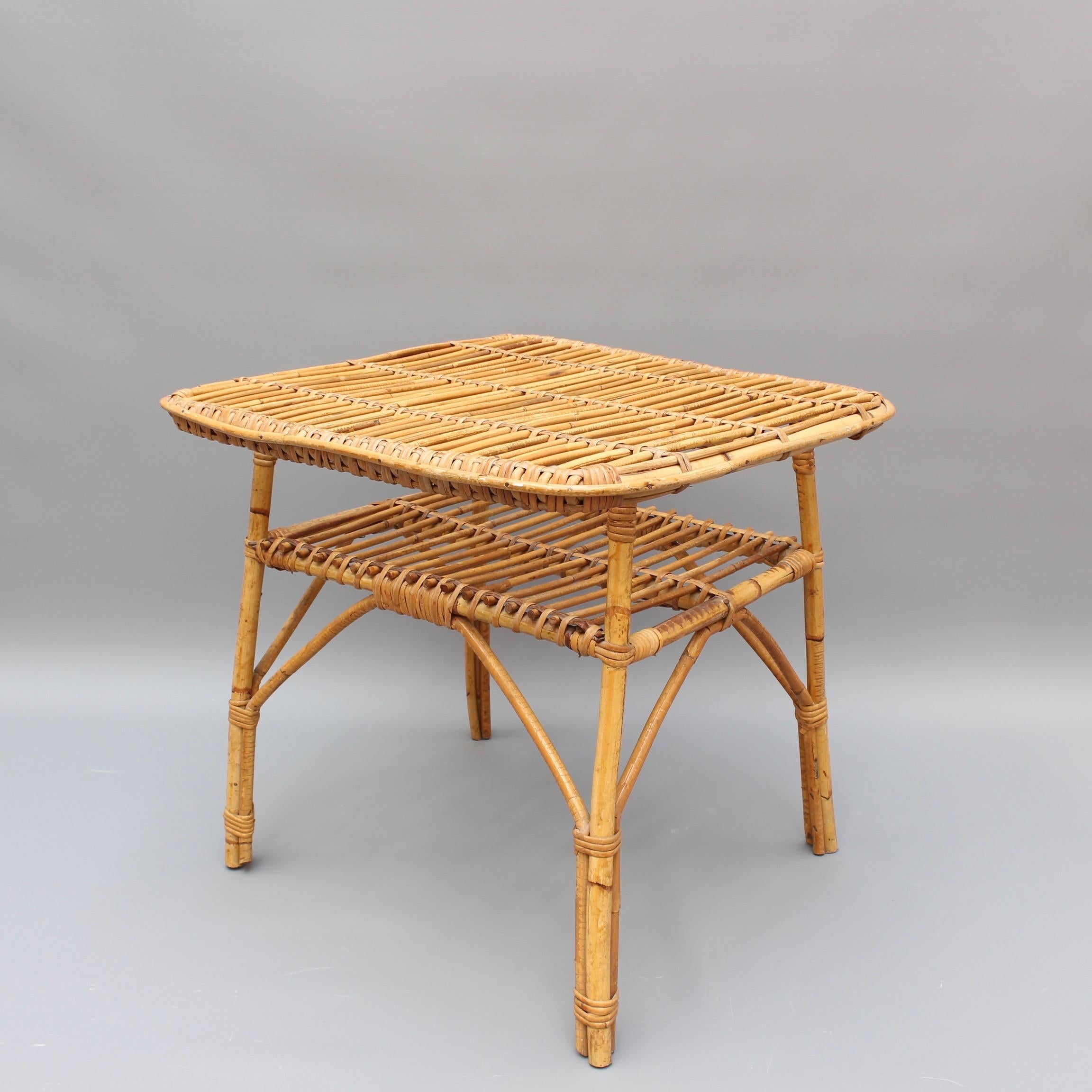 Rattan Italian coffee / end table (circa 1960s). A very stylish piece with slews of character and charm. There are two horizontal surfaces for storage or display. The smart-looking cane legs and frame are fastened together with tight-gripping but