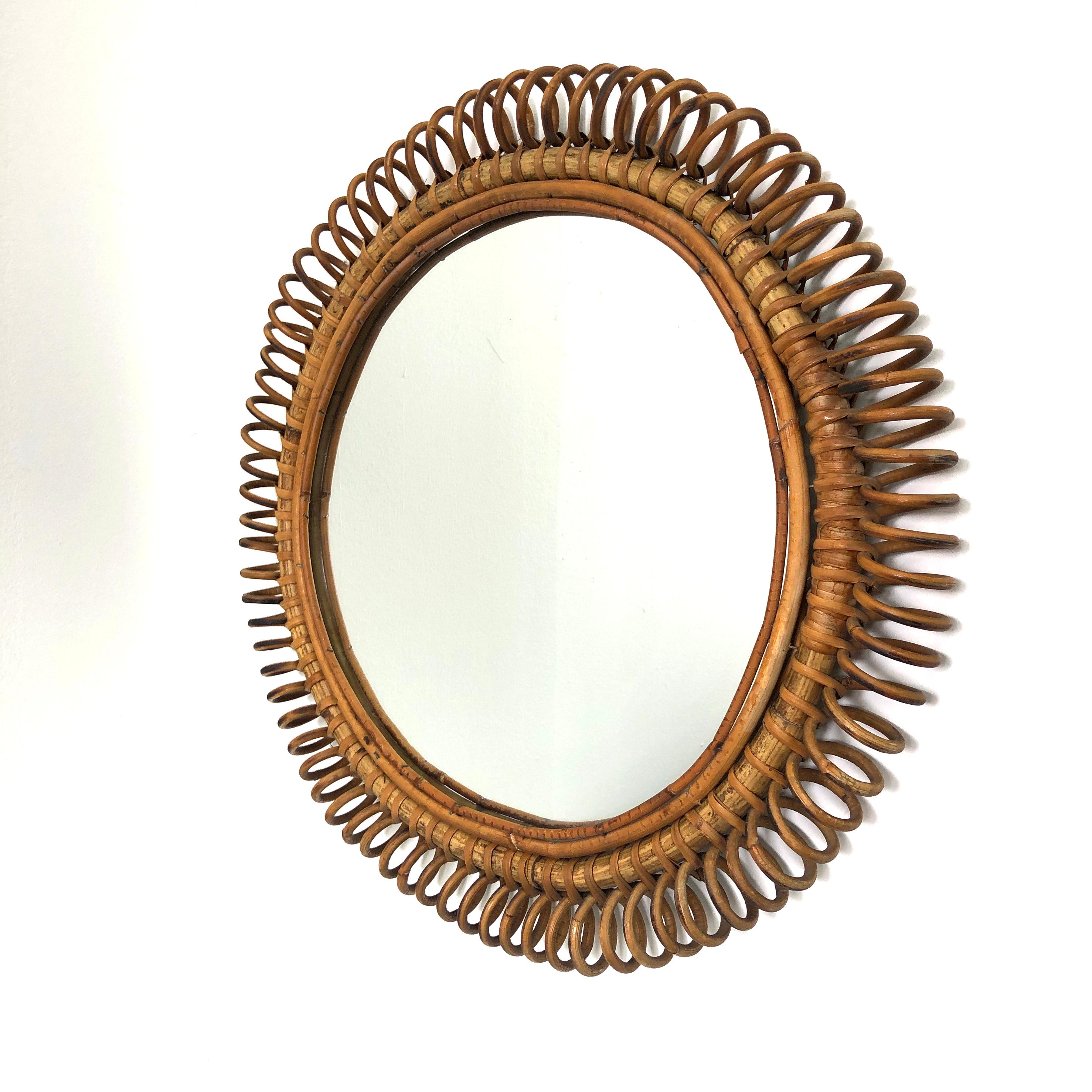 1960's round Italian rattan wall mirror. Rattan is worked in a deft curlicue fashion. This piece is very nicely proportioned and practically sized at 22