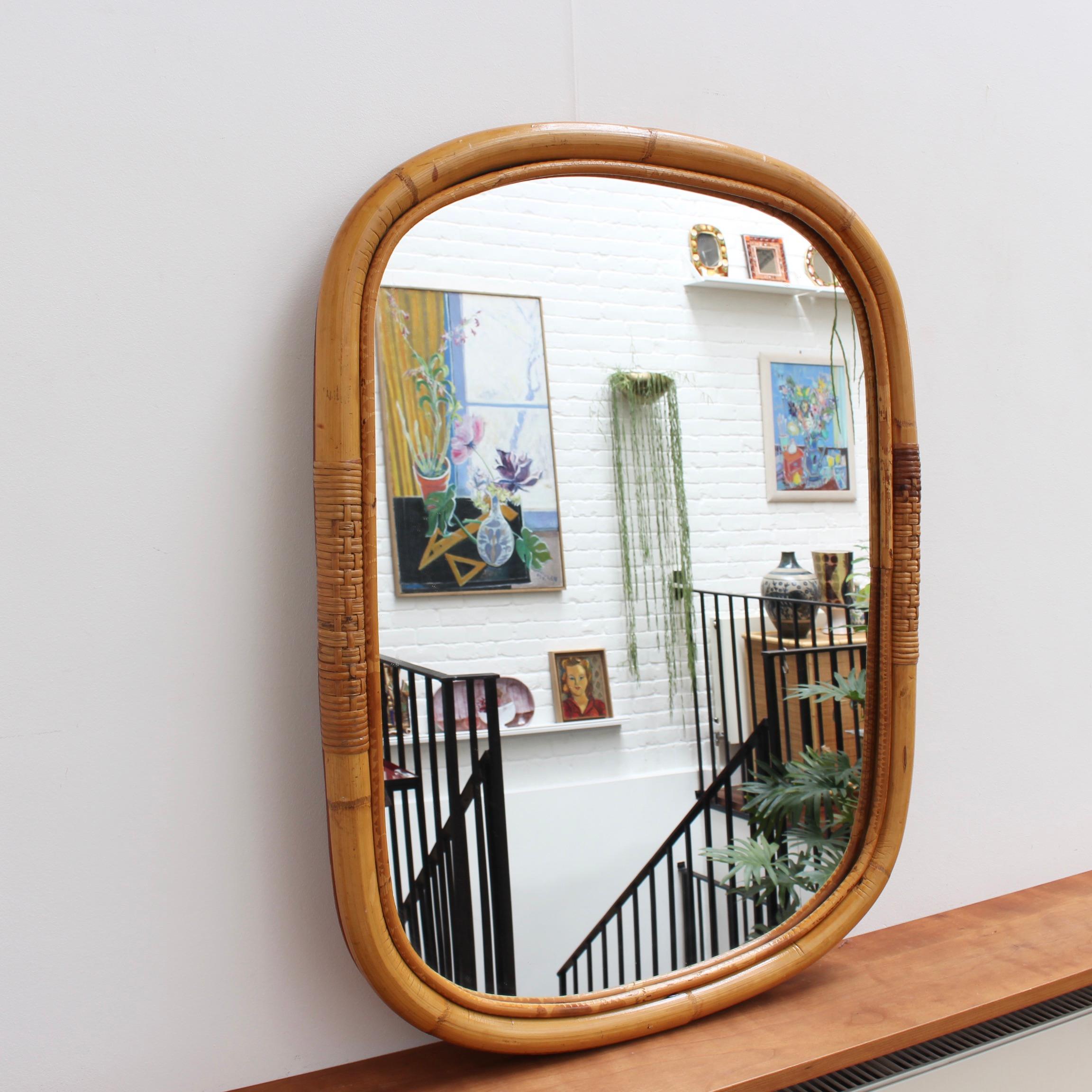 Mid-century Italian rattan wall mirror (circa 1960s). A distinctive vintage mirror which transports you immediately to another place and another time, perhaps the Italian Riviera or Miami's South Beach circa 1960. Its substantial glass is