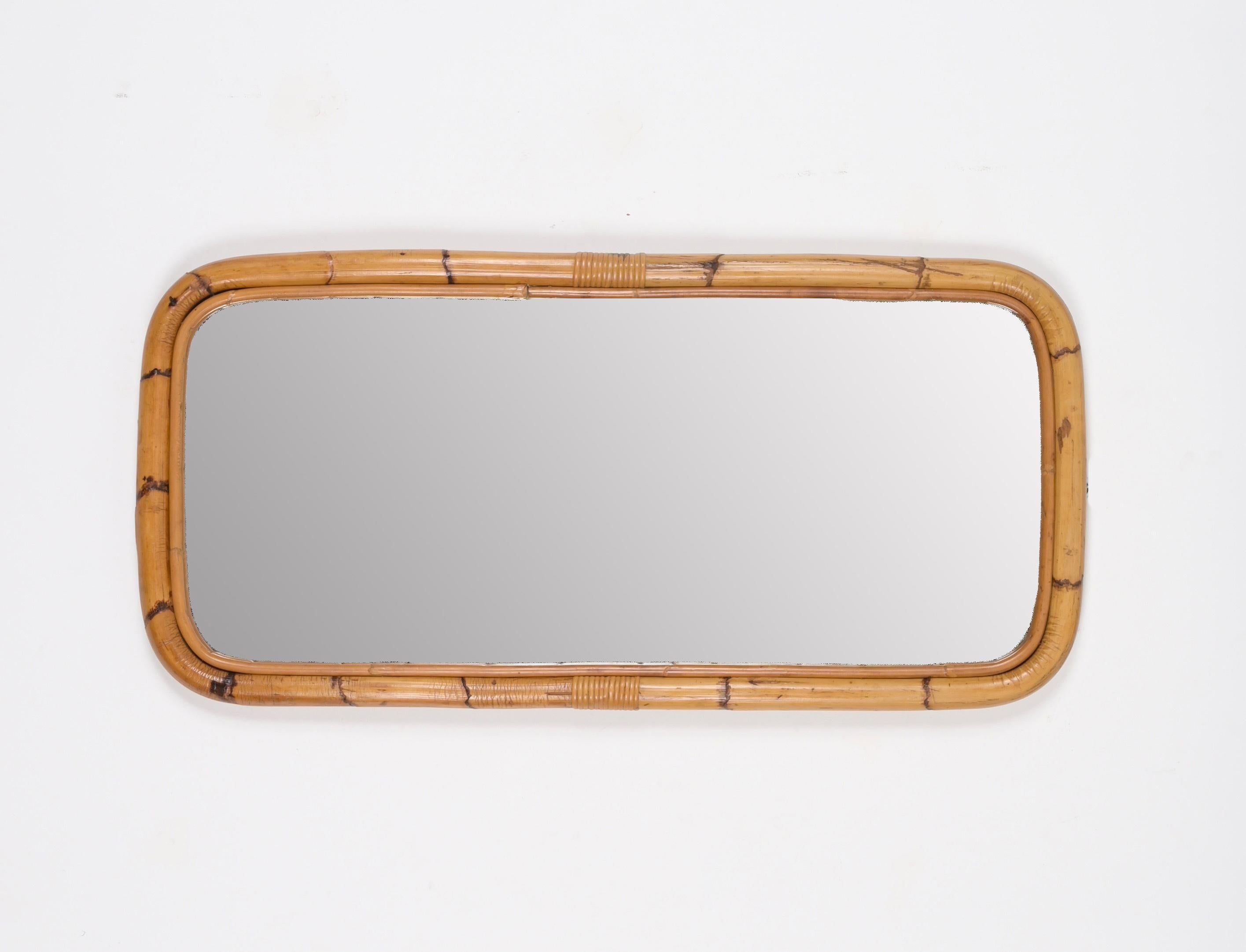 Superbe miroir rectangulaire de style Riviera française du milieu du siècle, en bambou incurvé et rotin tressé. Ce charmant miroir a été produit en Italie dans les années 1970.

Le miroir  a un design unique avec un double cadre en bambou courbé et