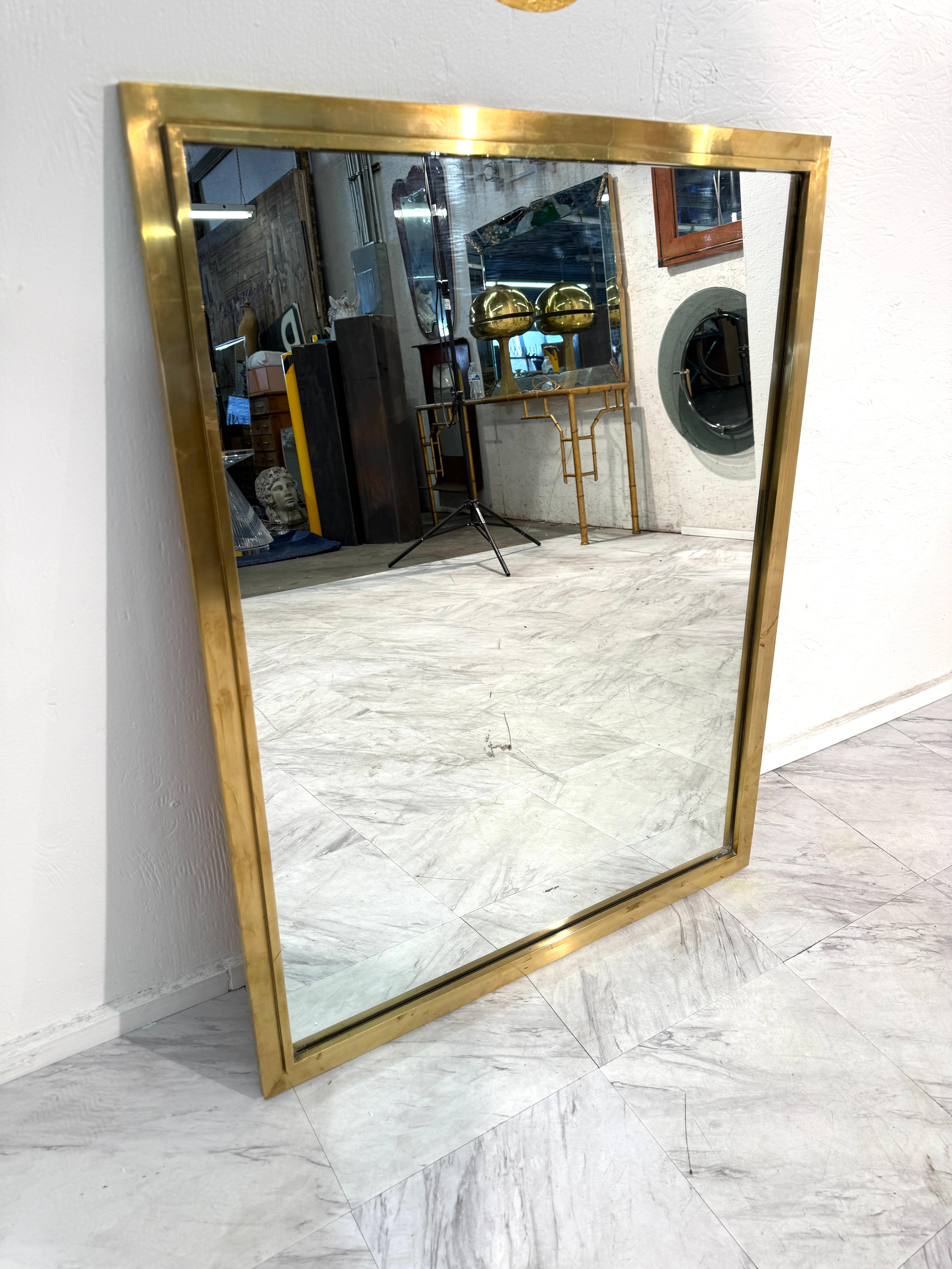 Elegante specchio rettangolare di metà secolo incorniciato in ottone massiccio, che emana un'artigianalità italiana senza tempo. Il design elegante e minimalista mette in risalto le linee pulite con una sottile profondità grazie al bordo in ottone a