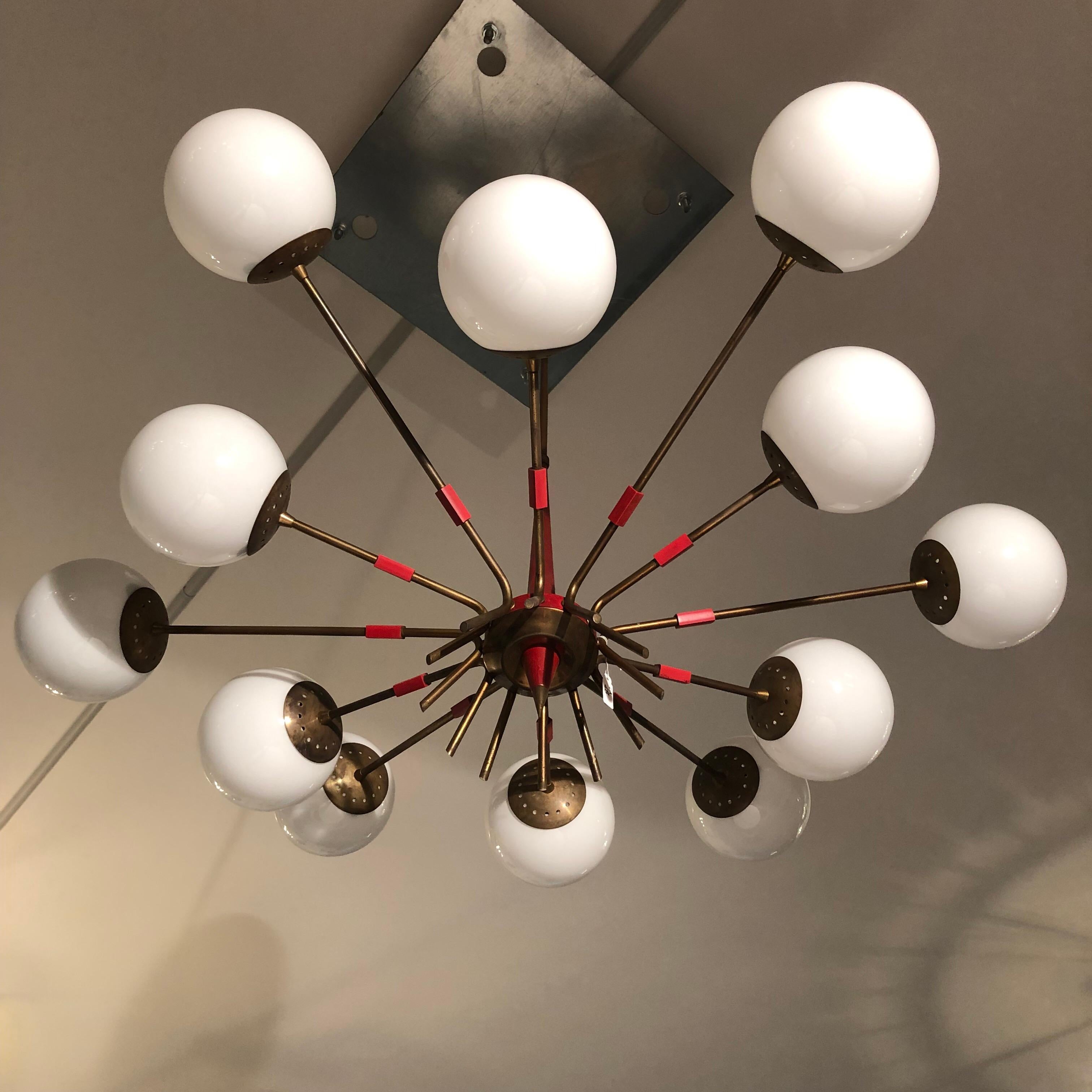 Italian midcentury chandelier by Stilnovo. 12 lights with E14 socket. Very good original vintage conditions. Brass, lacquered metal and opaline glass. Measures: Diameter 100 cm, total height with rod 103 cm. Glasses in perfect conditions, brass with