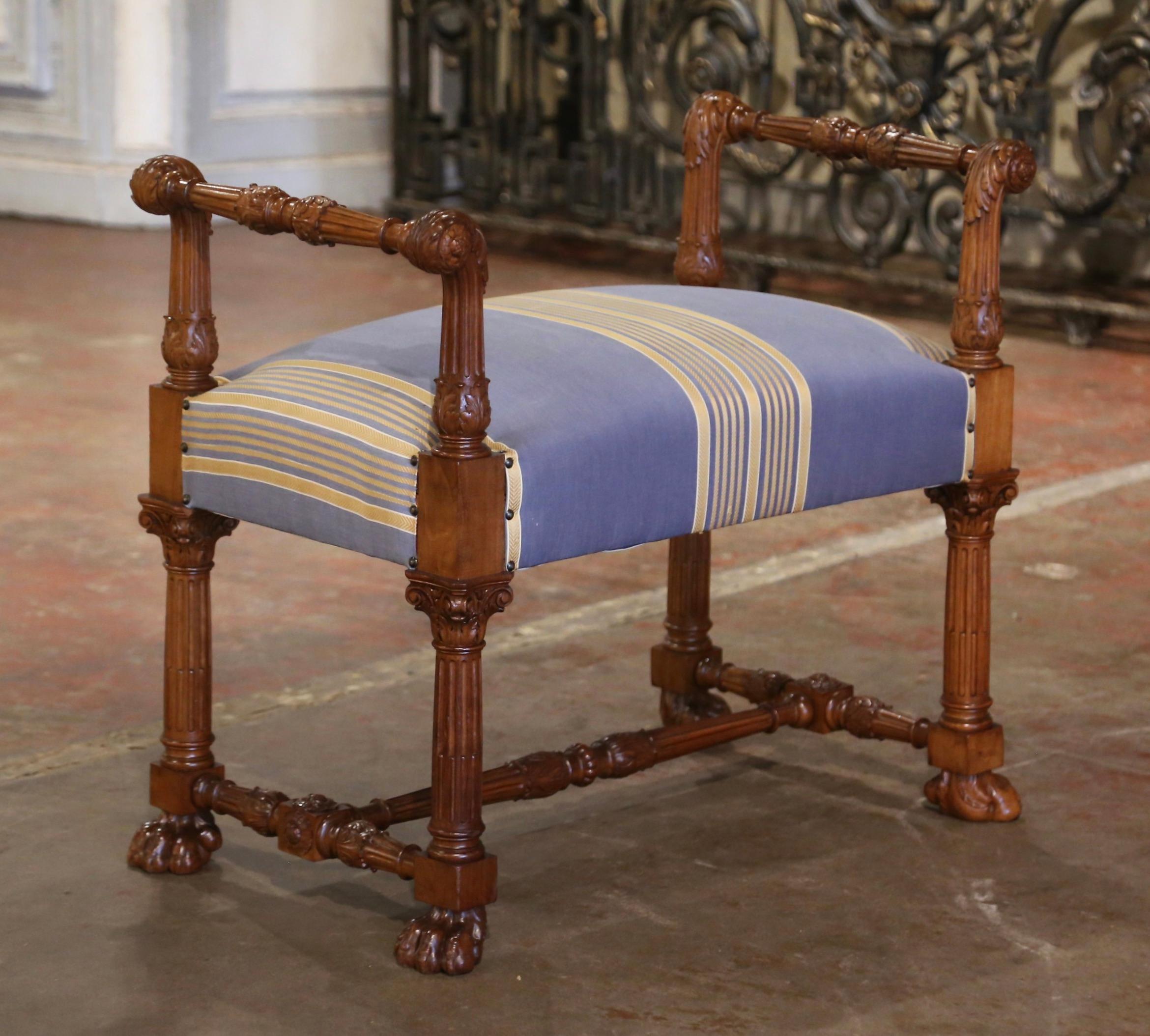This elegant vintage fruit wood bench was crafted in Italy, circa 1970. The antique seating stands on fluted legs ending with paw feet over a bottom carved stretcher at the base embellished with carved floral rosette medallions. The stool features