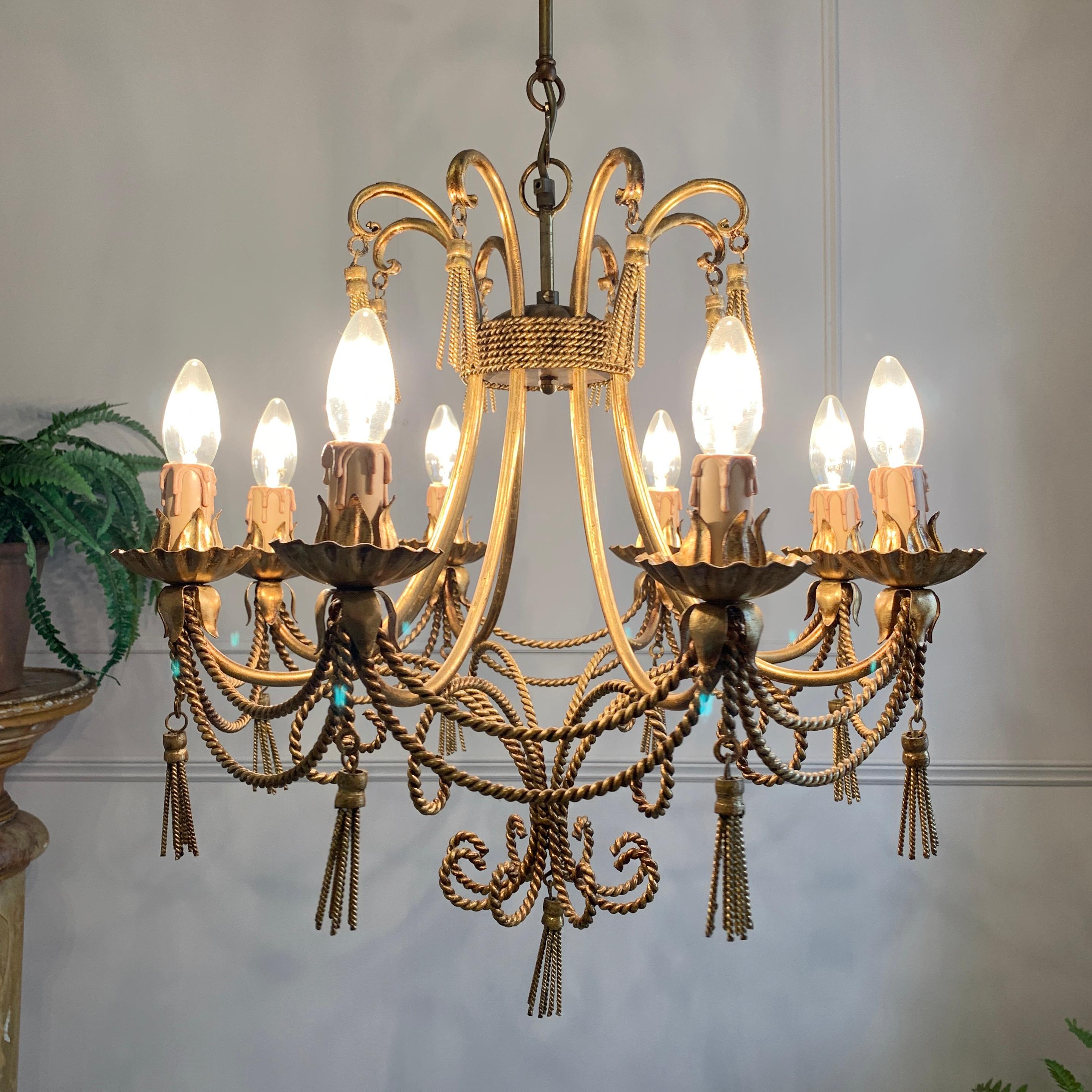 A beautiful twisted rope Italian chandelier, dating to the 1950's and crafted from gilt covered steel. The rope and tassel detailing on this light is impeccable and oozes mid century Hollywood glamour
The chandelier has 8 bulb holders, each taking