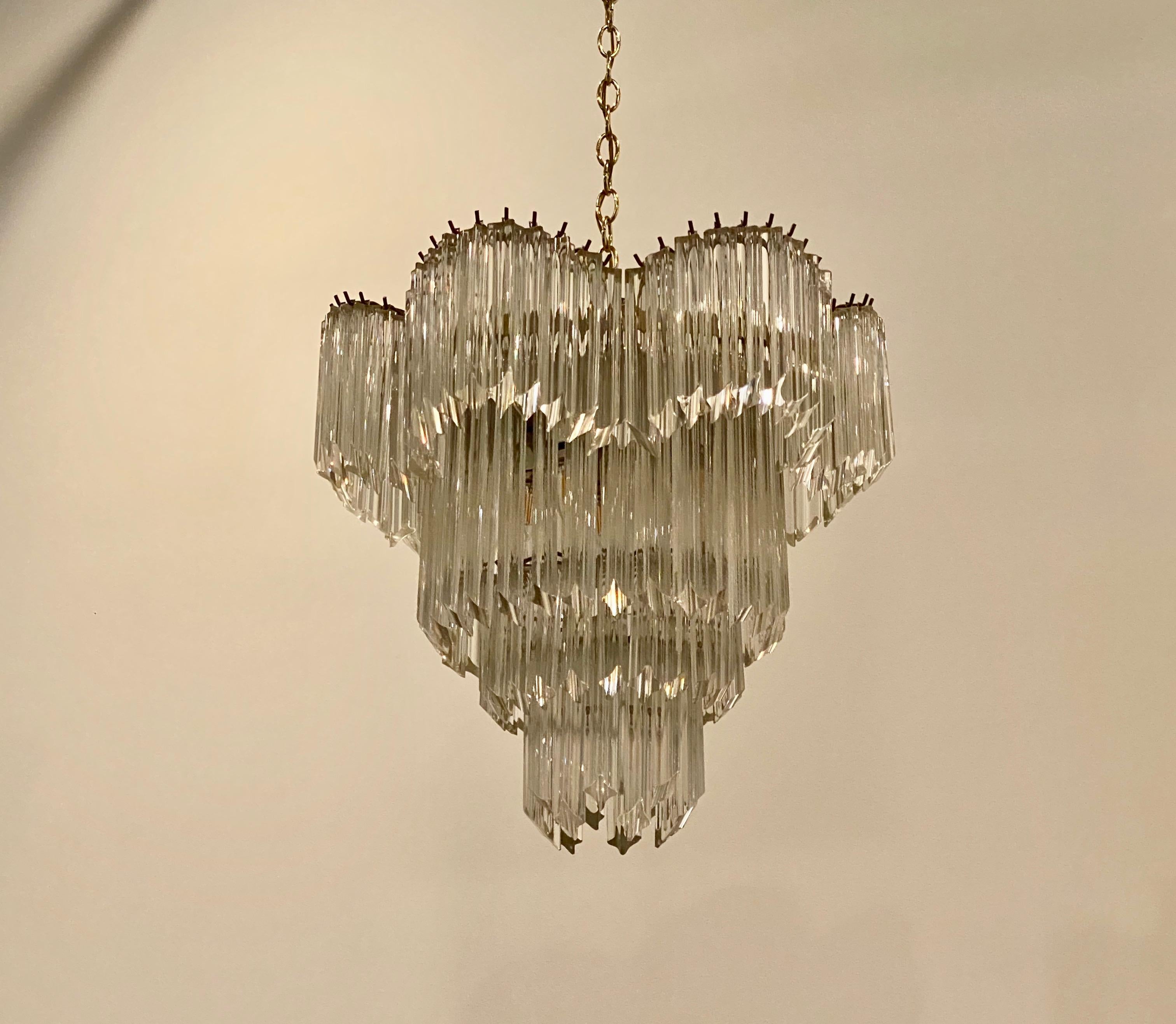 Mid-Century Modern Italian tiered chandelier. Each of the prisms are solid glass. They hang from hooks on a brass frame, as pictured. Any amount of chain can be added or subtracted for custom hanging length of the chandelier. Has been rewired for