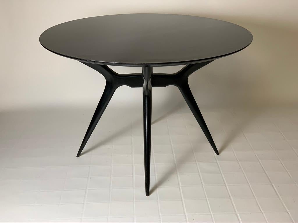 Round black laquered wood dining table or centre table made in Italy in the 1950s, four thin and tapered legs cross to support the round top.
Mid-Century Modern.
