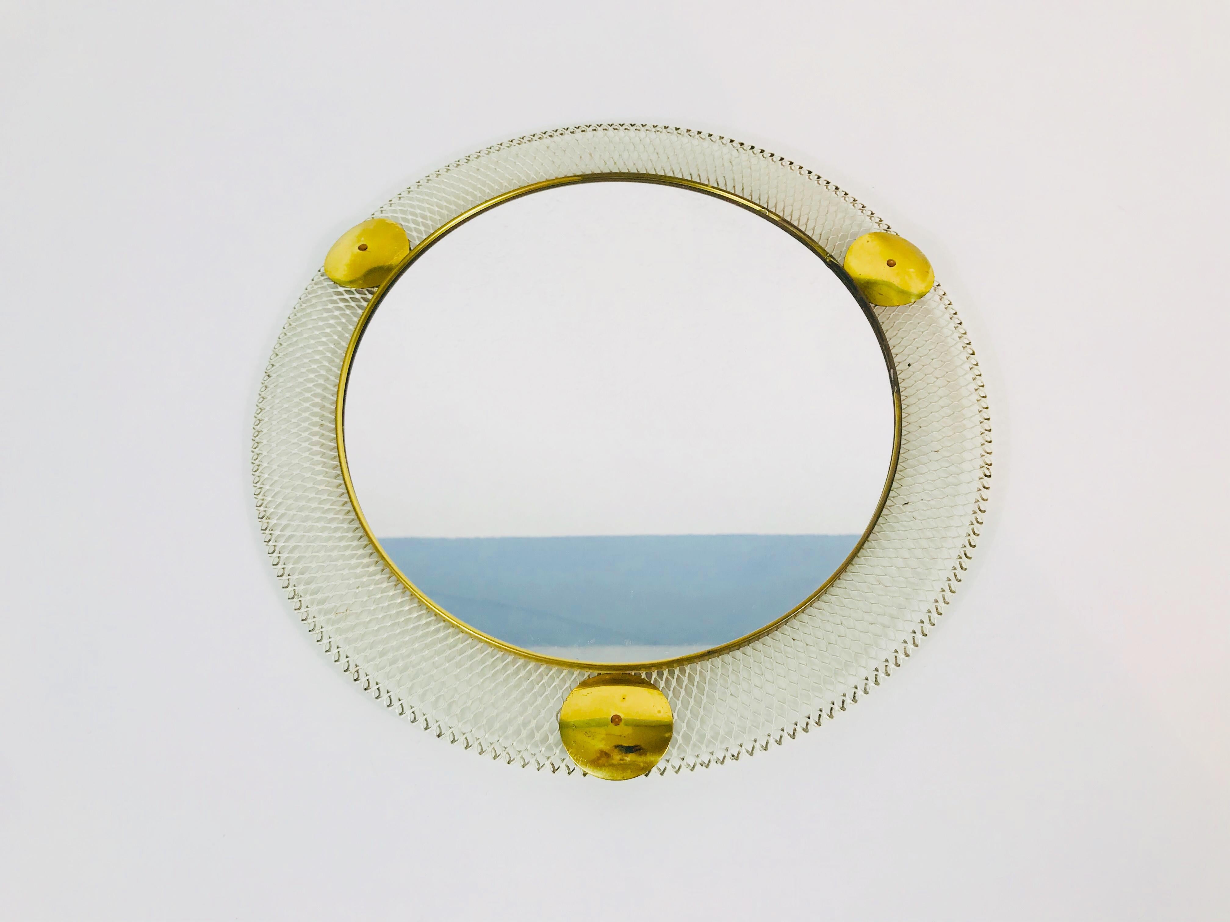 A round wall mirror from the 1960s made in Italy. The mirror has a circular metal design. The mirror is in a good vintage condition.