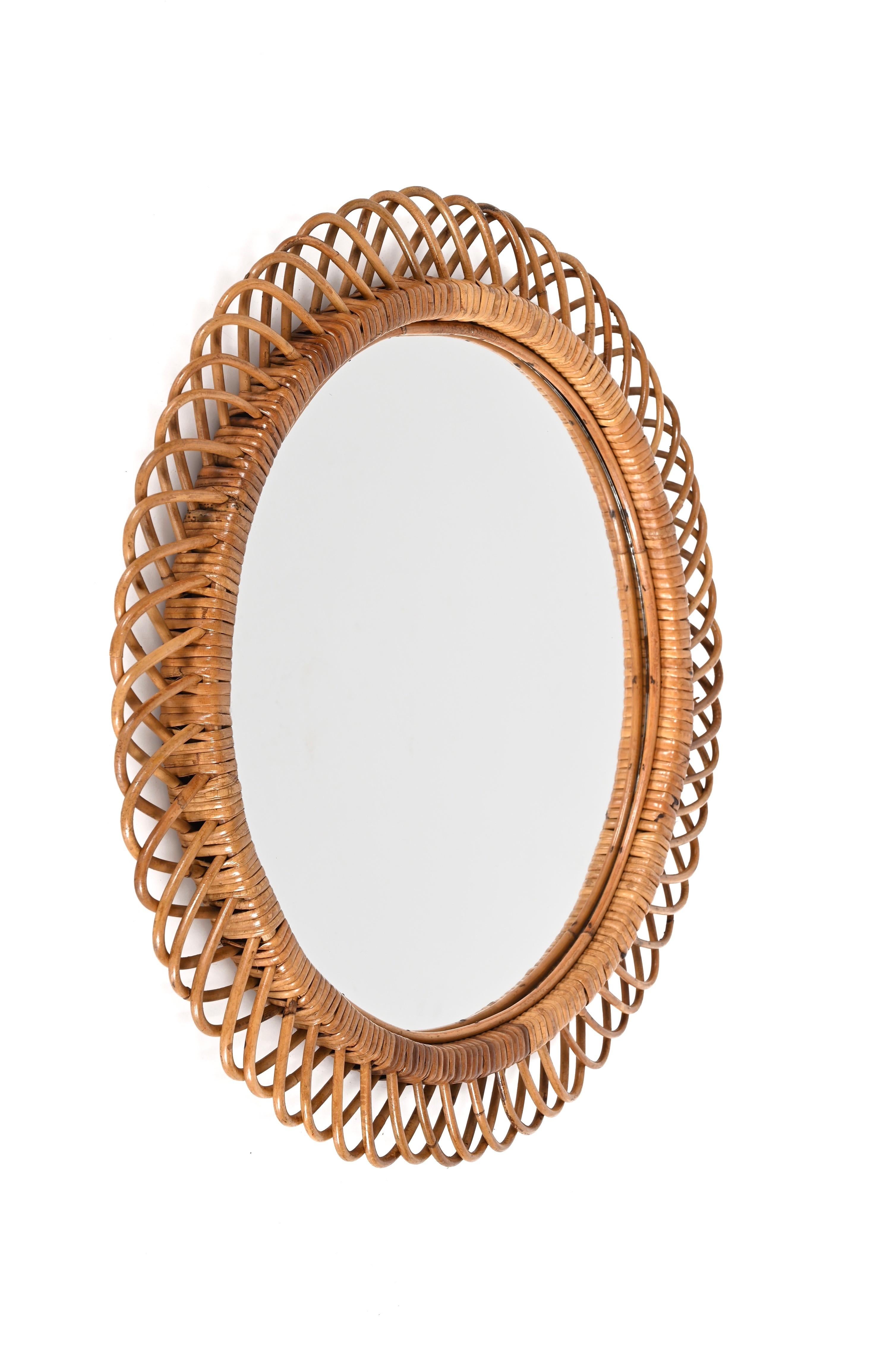 Gorgeous midcentury French Riviera rattan and bamboo round mirror. This stunning piece is attributed to Franco Albini as designer and Bonacina and was produced in Italy during the 1960s.

This decorative round mirror is unique as it has a curved