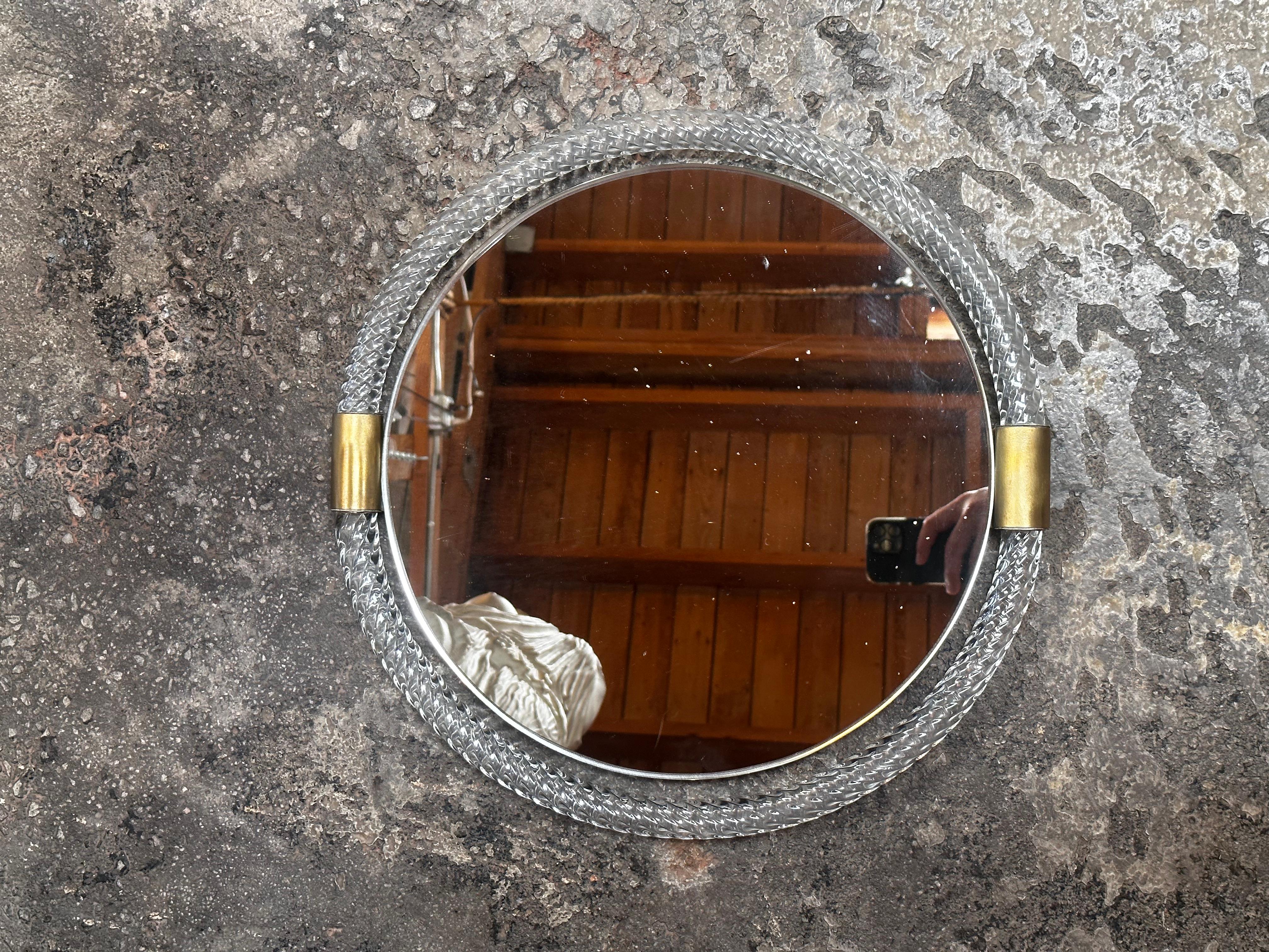 The Mid Century Italian Round Murano Wall Mirror from the 1960s is a circular mirror that exemplifies the iconic design of the era. Created in Murano, Italy, it displays the exquisite craftsmanship and artistic flair that Murano glasswork is