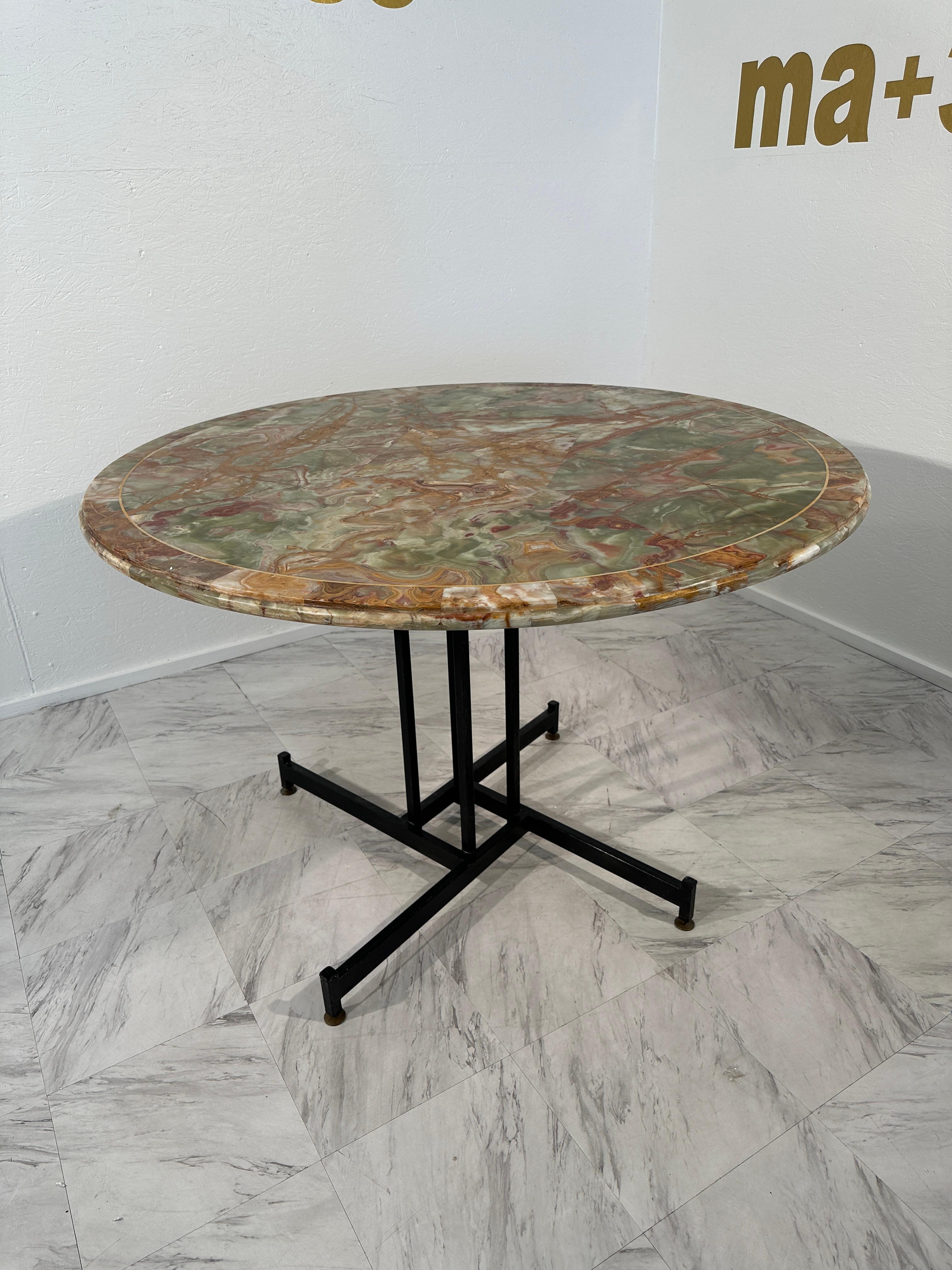 The Mid Century Italian Round Table by Ignazio Gardella, crafted in the 1950s, is an exquisite piece characterized by its elegant design and quality materials. The table features a round top made of luxurious onyx marble, showcasing intricate