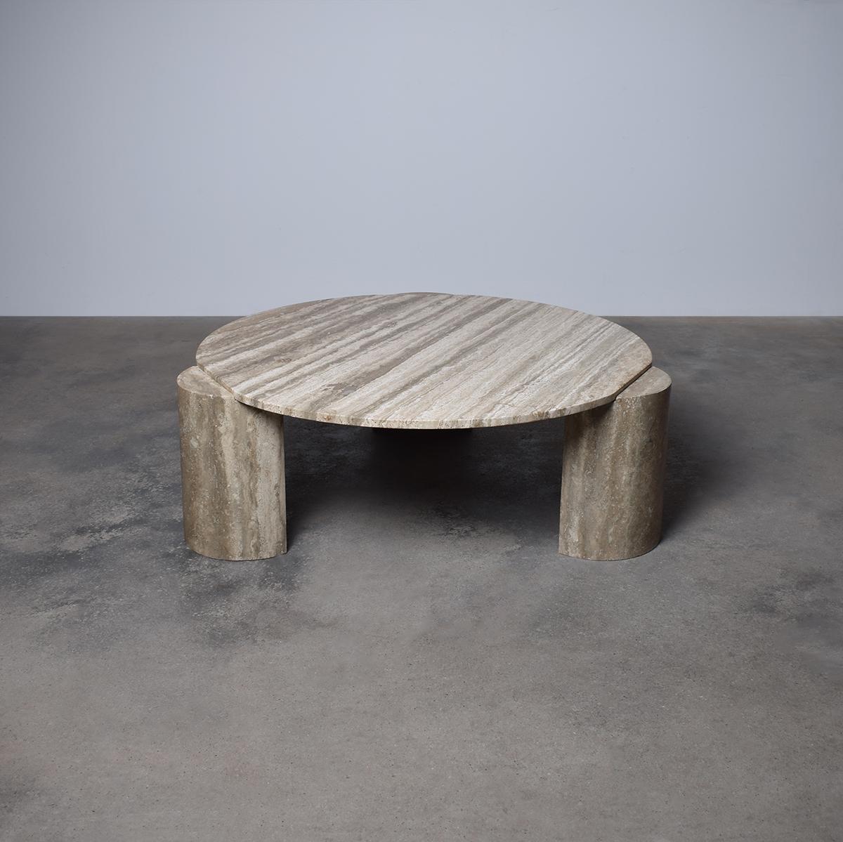 Table basse ronde italienne en travertin du milieu du siècle dernier, datant des années 1970. Le plateau circulaire et lisse en travertin met en valeur la beauté naturelle de la pierre, avec des tons beiges doux et des motifs de veines uniques.