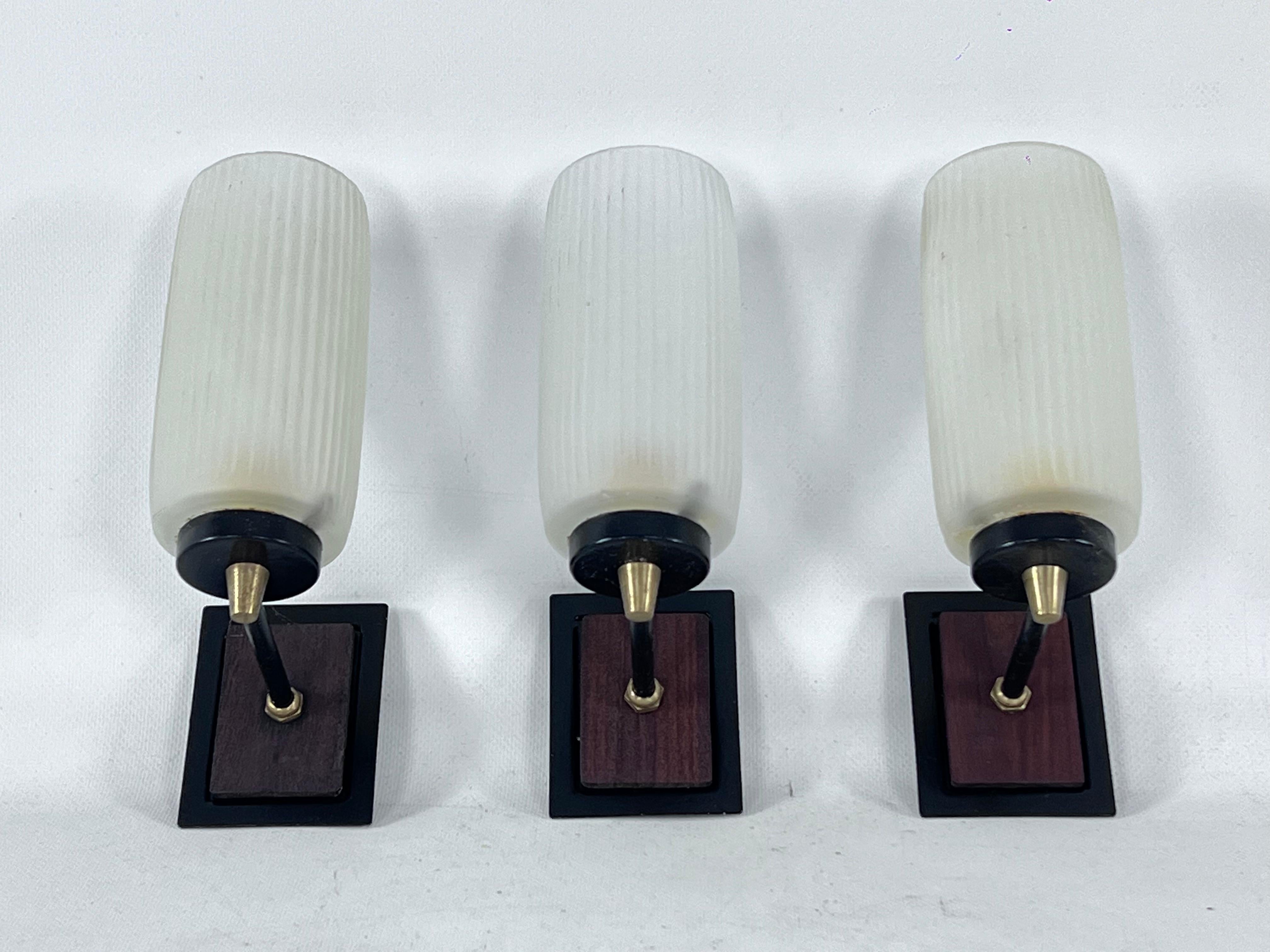 Great vintage condition with normal trace of age and use for this set of three sconces produced in Italy during the 50s. Made from glass, brass, lacquer and wood. No chips or cracks