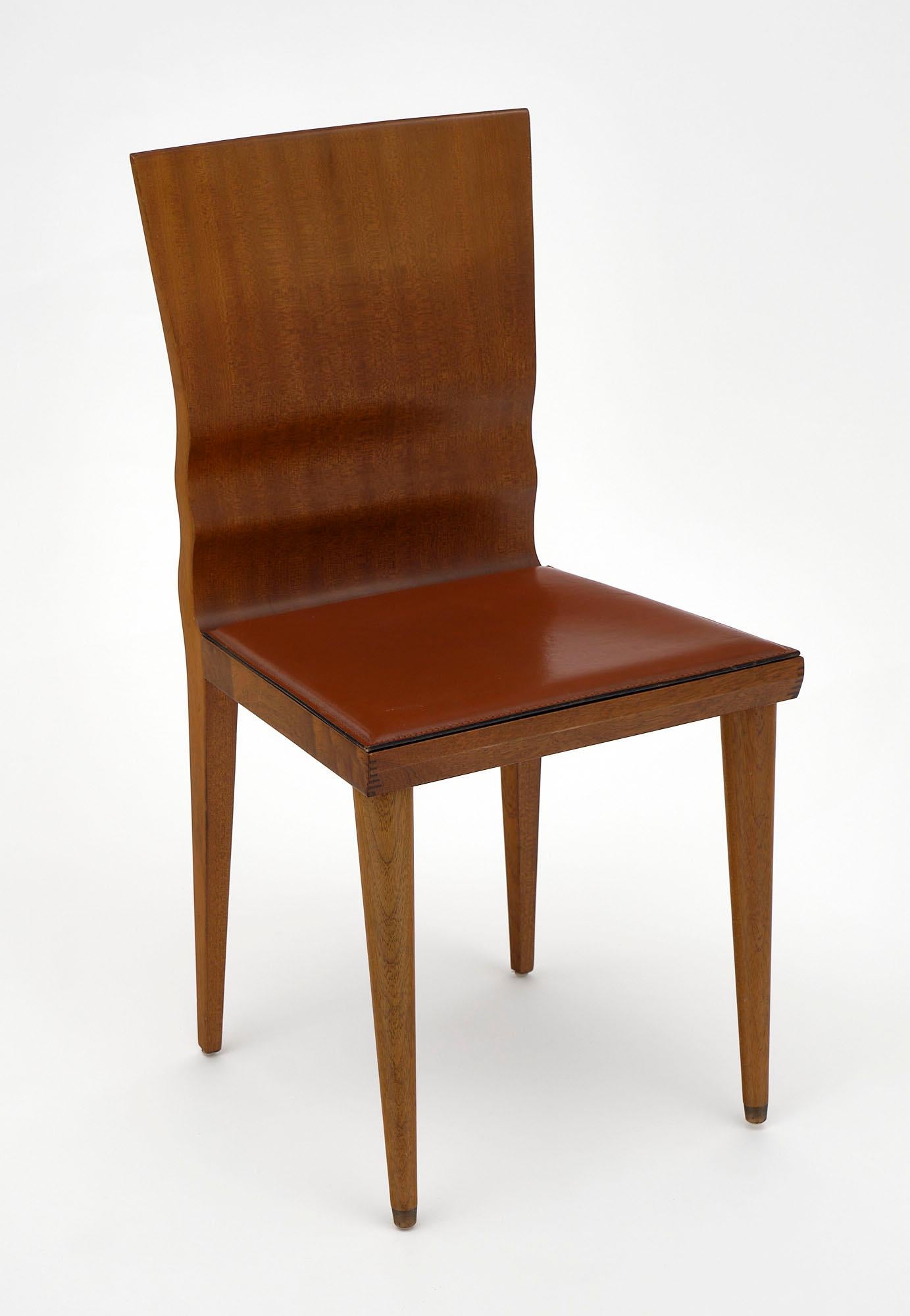 Set of four chairs from Italy designed by William Sawaya for Sawaya and Maroni made of solid walnut with padded leatherette seats. They have a beautiful undulating back and tapered legs.