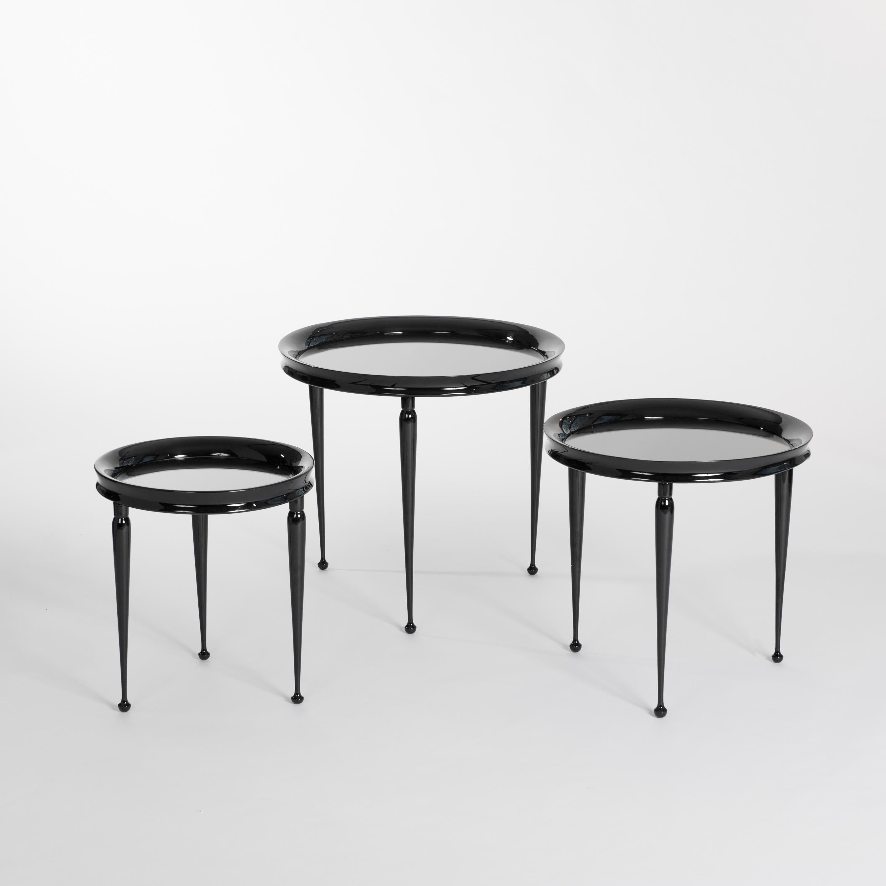 Midcentury set of 3 grazile round nesting tables black lacquered wooden frame and grey colored mirrored top.
The tables frame is curved inward, the round legs ends in a little cone.
1) Diameter 51cm x height 46.5cm
2) Diameter 43cm x height