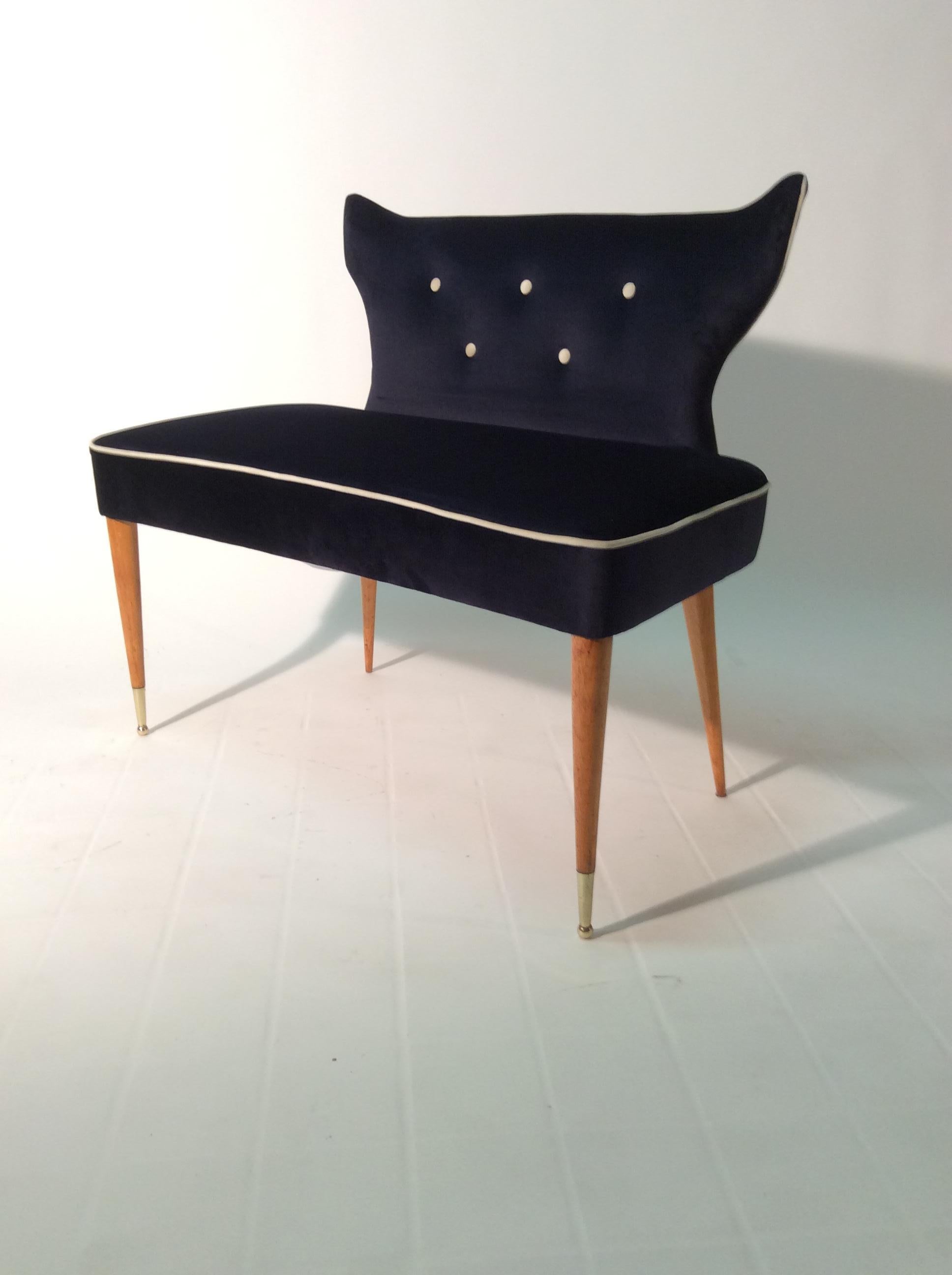 Small sofa or stool with backrest, Italian Settee 1950s with wooden legs and brass feet, newly covered with dark blue velvet.
Beautiful shaped and curved back, this small sofa or stool can be positioned at the bottom of a bed, in a guradroba,