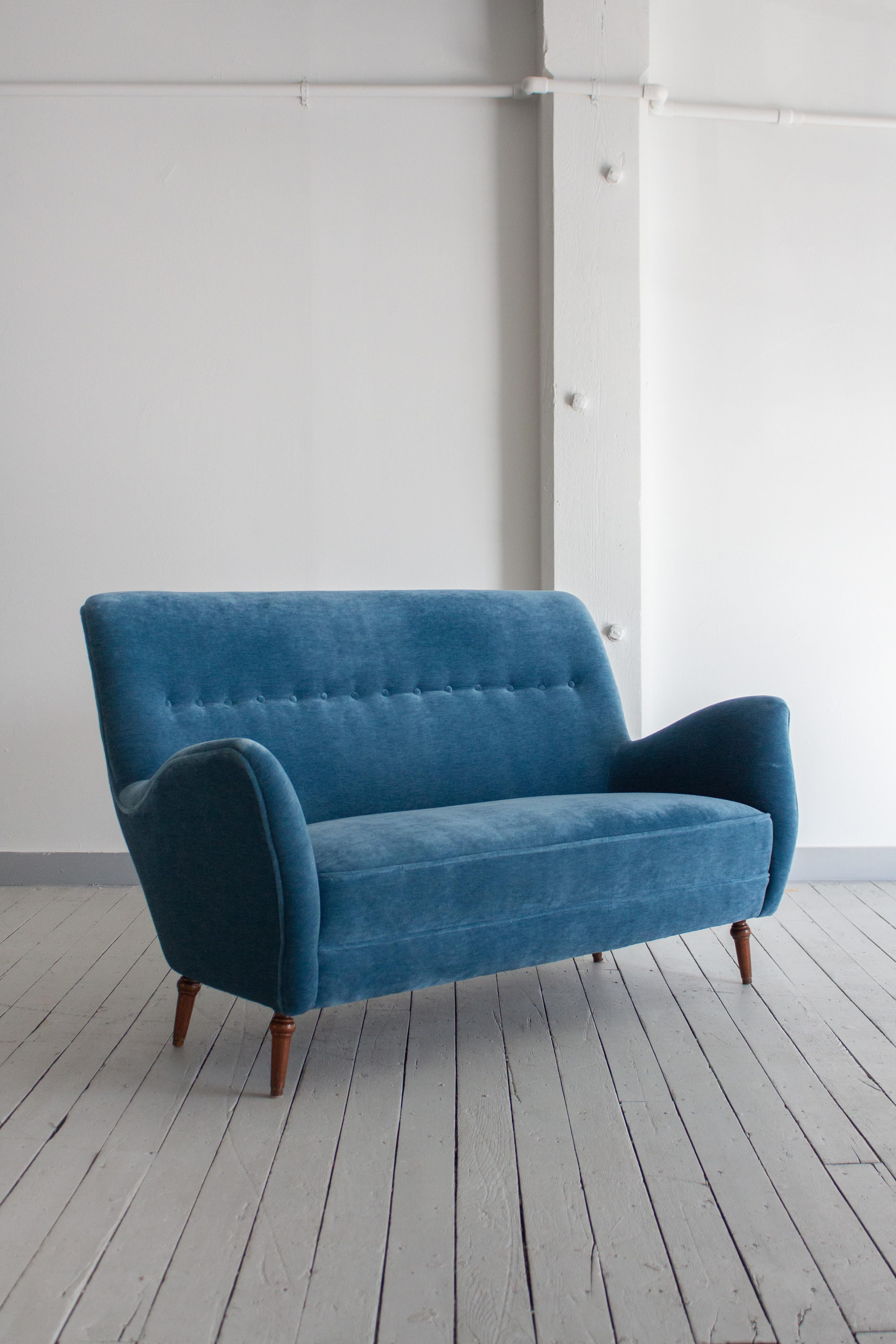 A mid century Italian settee. Newly reupholstered in a warm blue mohair. Tufted back and turned wood legs. Sourced in Northern Italy.