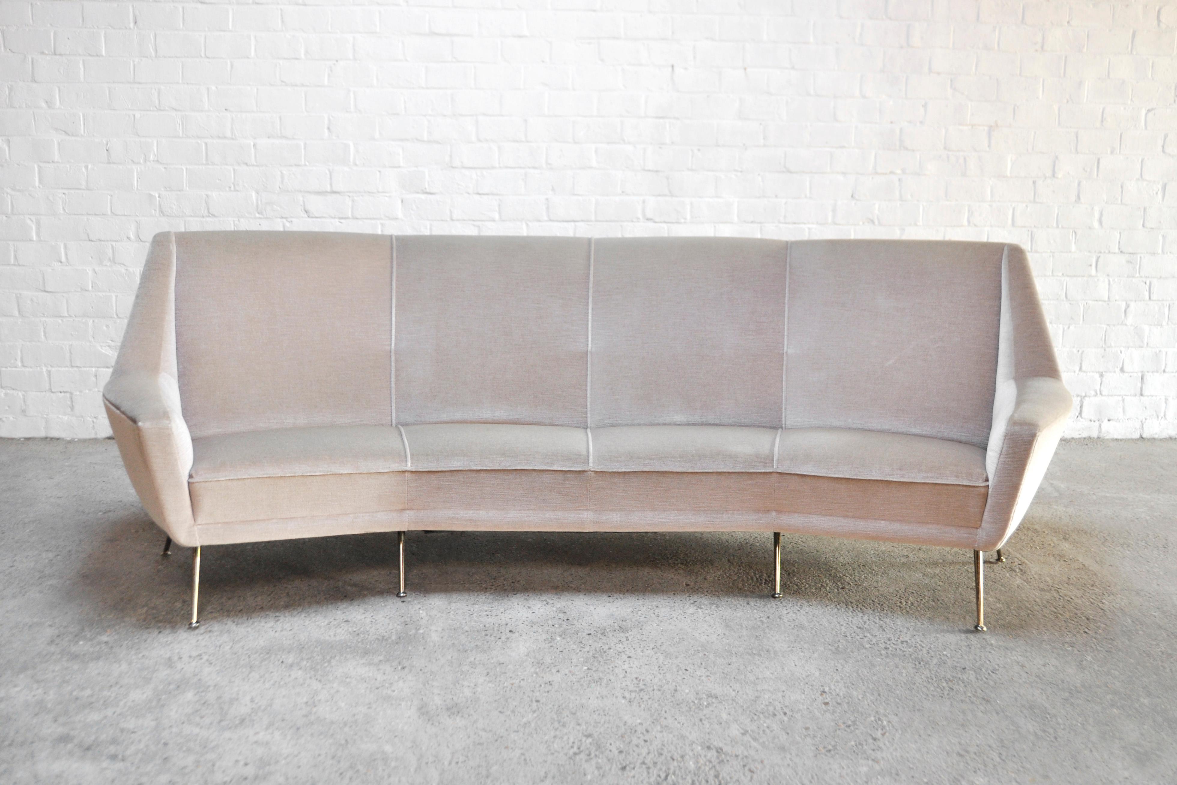 Large Italian curved four-seater sofa composed of six splayed polished legs, large wing shaped arms and a curved high back, in the style of Ico Parisi. Upholstered in beige fabric.

In near perfect condition, almost no signs of pre-use.