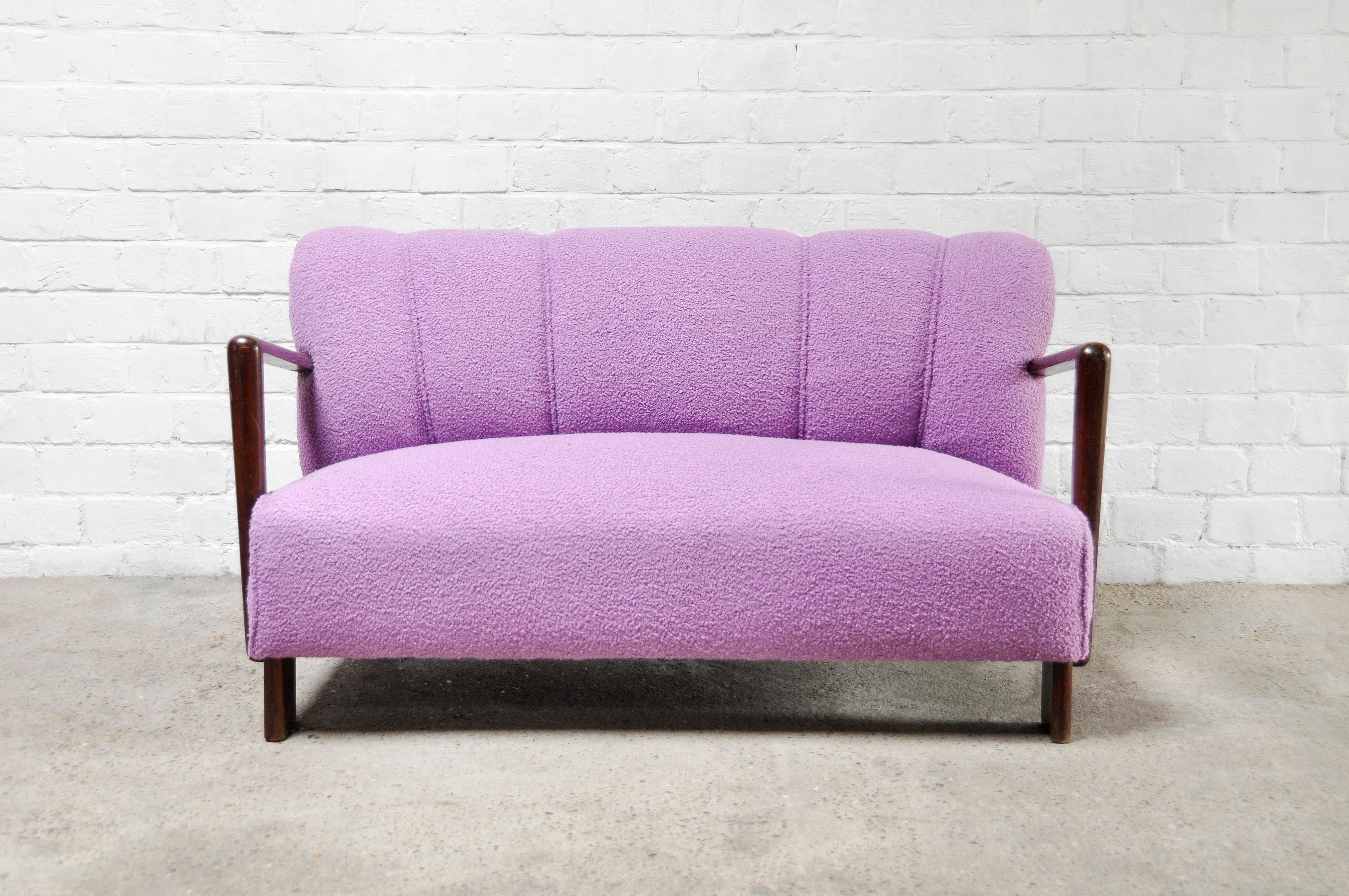 Beautiful Italian two seater sofa in purple bouclé wool, 1950s. The fabric is newly reupholstered in a warm and soft purple bouclé fabric. The unique feature of this loveseat sofa is its angular sculptural wooden armrests. The back of this sofa