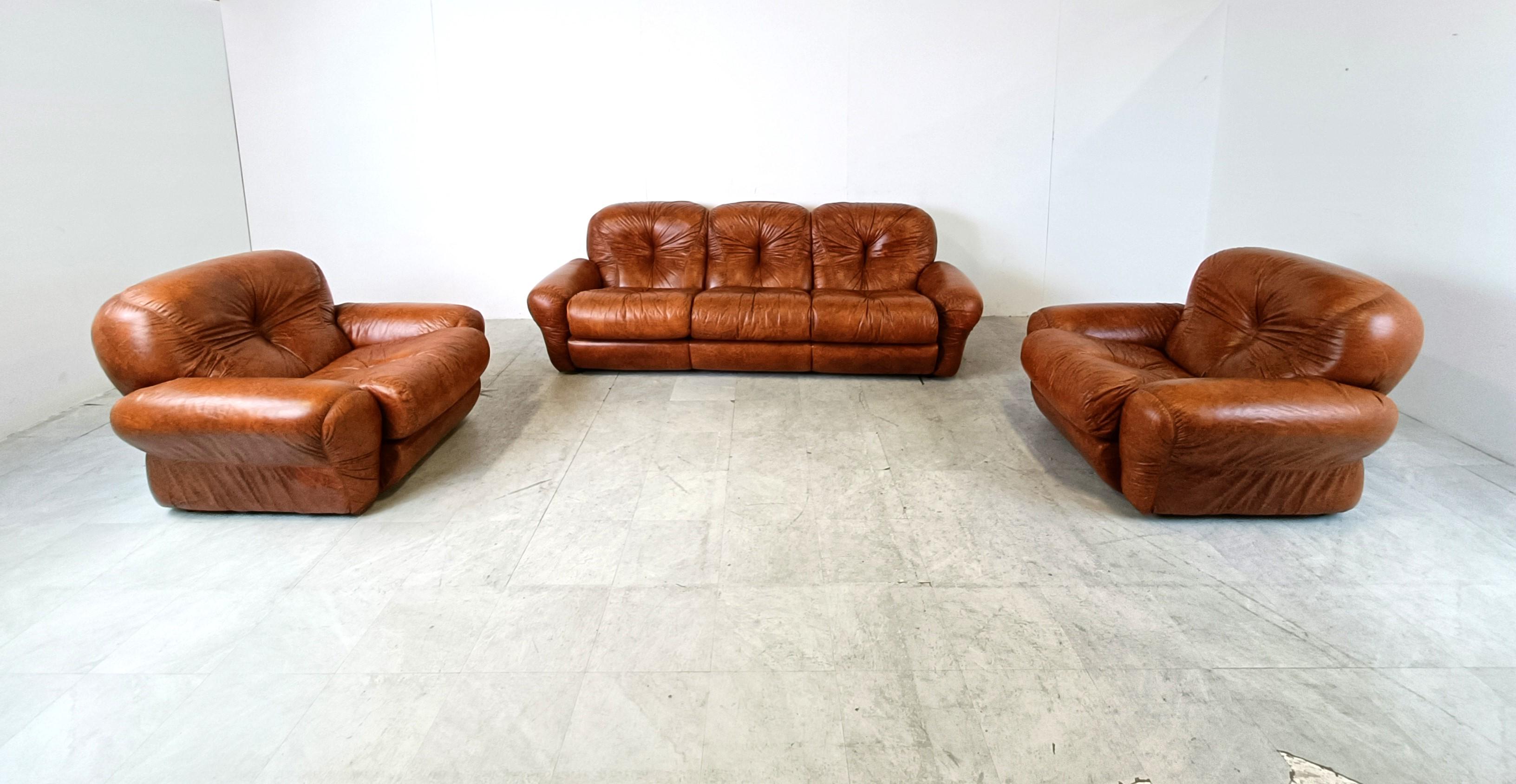 Mid century sofa set in brown faux leather designed in italy in the 1970s.

Very thick and comfortable cushions with an elegant design.

The set consists of a three seater sofa and two armchairs

Good original condition.

1970s -