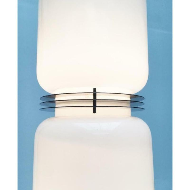 Lámpara de pie muy rara de cristal opalino y cromo. Los diseñadores o fabricantes no están identificados. El lenguaje formal y la ejecución indican un origen italiano (Mazzega, Vistosi, Valenti, etc.). Las costillas metálicas se conocen por Enrico