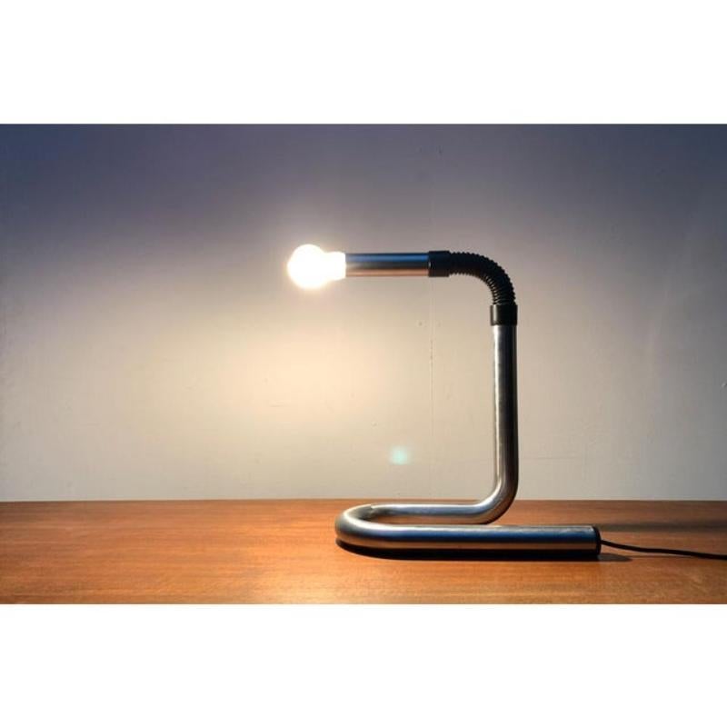 Lampe de table italienne de l'ère spatiale avec tête lumineuse flexible.

Le corps lumineux est constitué d'un simple tube. A l'extrémité supérieure, il est séparé et pourvu d'un joint. Dans la partie inférieure, le tuyau forme une boucle au pied de