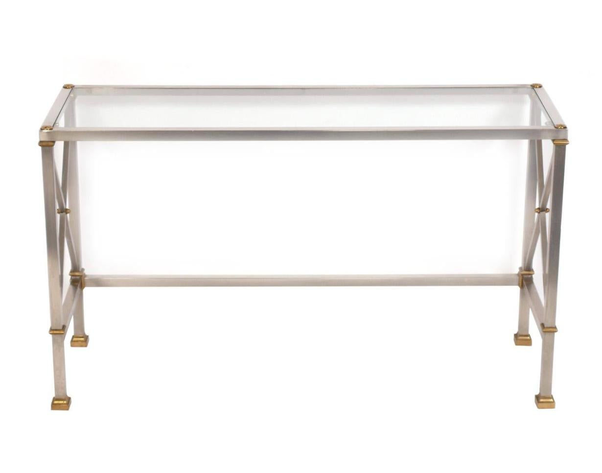 An elegant mid century Italian console or sofa table made of stainless steel and brass with a glass top in the style of Maison Jansen. This console table is stamped underneath Made In Italy. With its clean lines and versatile size, this table can