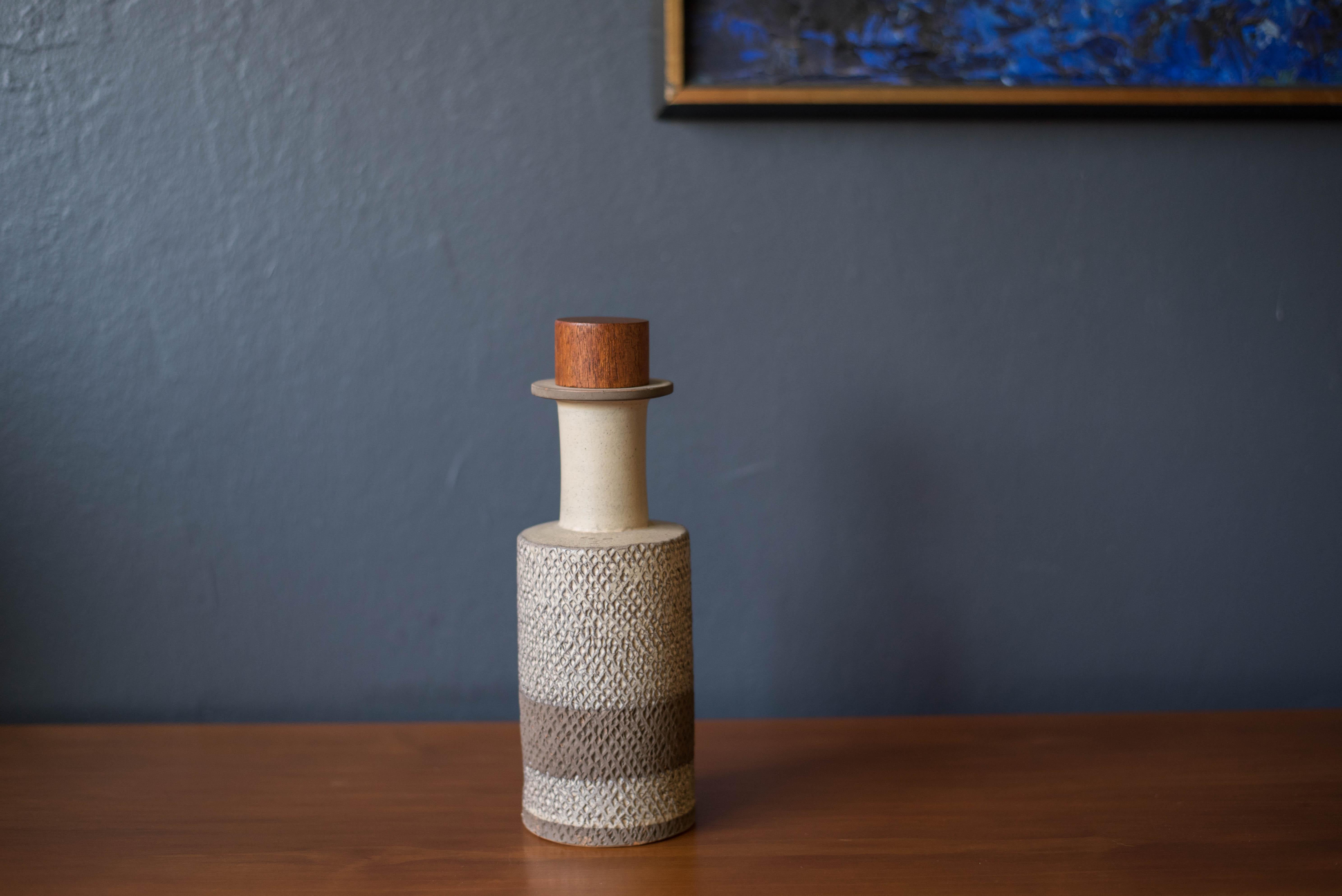 Vintage Bitossi ceramic pottery vase imported by Raymor. This contrasting two-toned clay vessel is incised with a diamond pattern in an earth tone matte finish. Fitted with a teak stopper made in Denmark. Handmade with subtle imperfections making