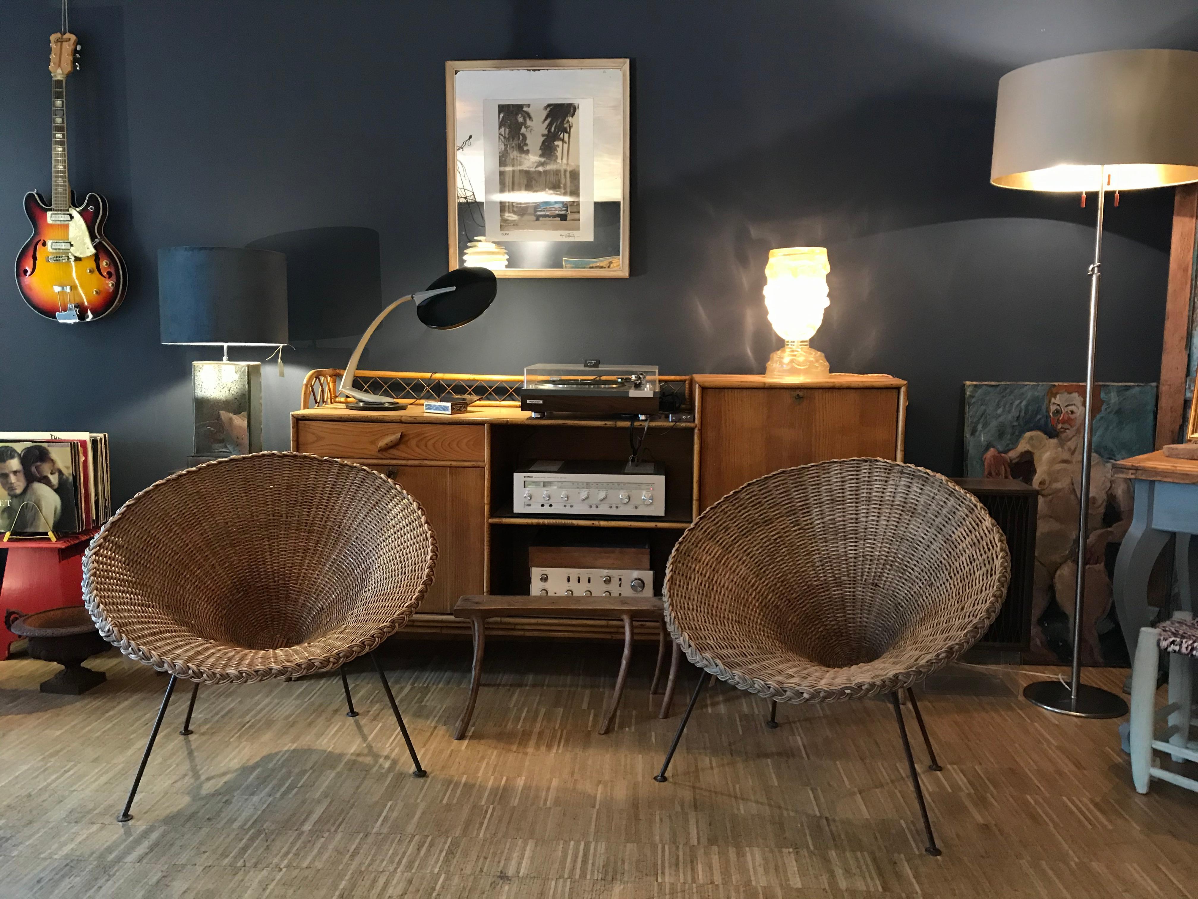 Large pair of sunflower-shaped rattan chairs. Designed in the style of Roberto Mango. Features a base in polished iron rod. Wicker seats are removable for storage.