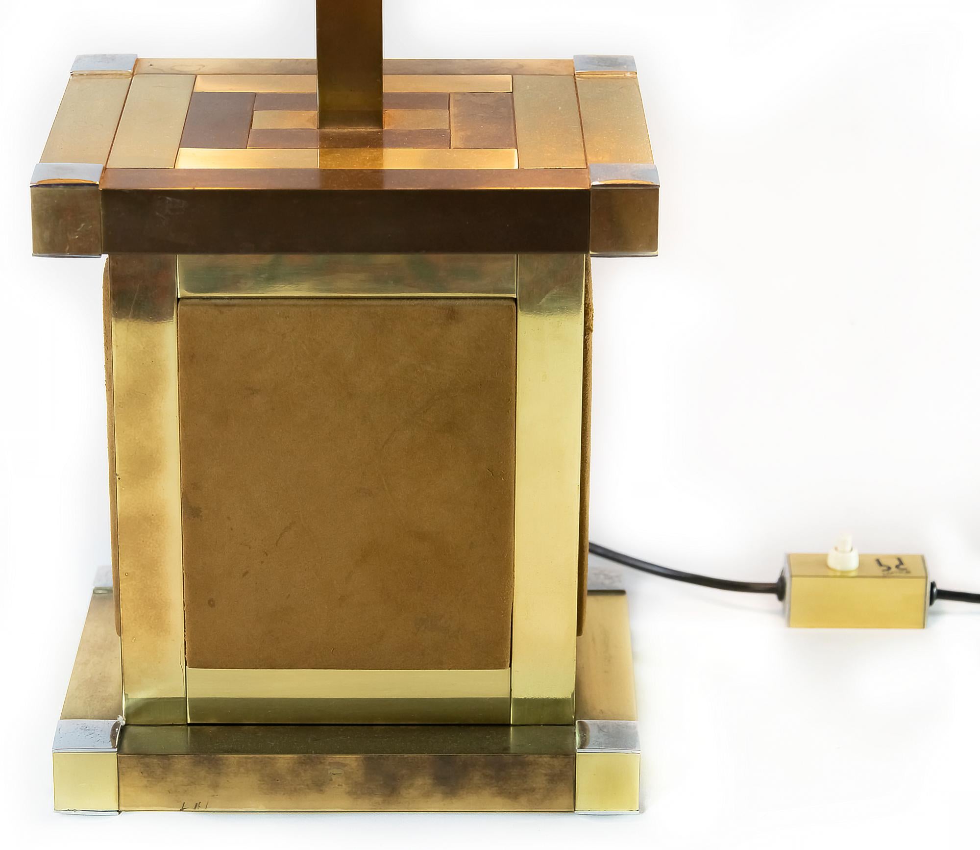 Lampe de table italienne du milieu du siècle en laiton et chrome doré, décorée d'éléments en cuir de daim naturel sur tous les côtés de la base. 
Il y a 3 pcs. d'ampoules E24, qui peuvent être changées séparément. 
L'abat-jour est neuf, en textile