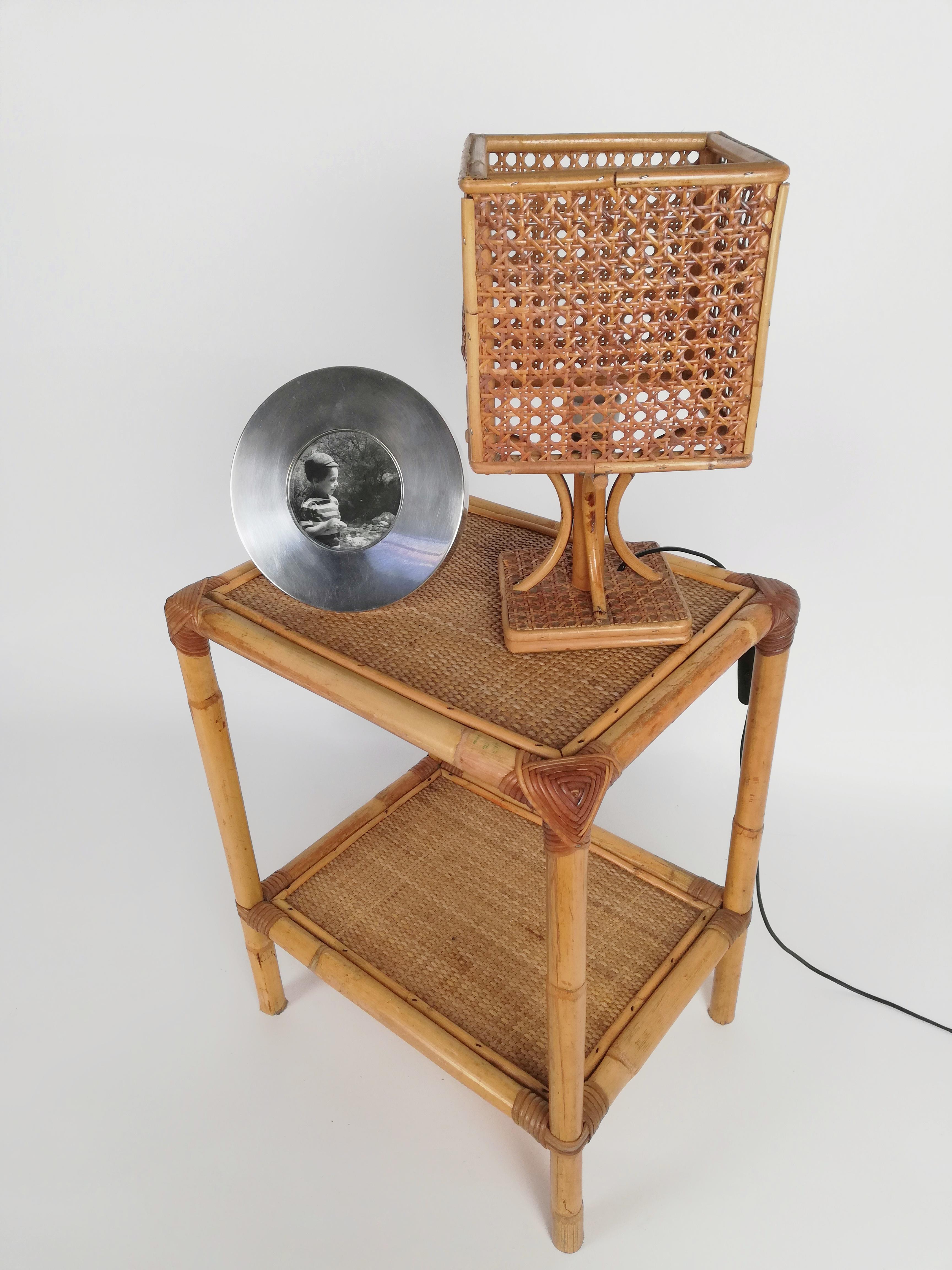 Eine Tischleuchte aus der Mitte des Jahrhunderts, die zwischen den 1950er und 1960er Jahren in Italien handgefertigt wurde.
Die Struktur der 33 cm hohen Lampe besteht aus gebogenen Rattanstöcken und der Lampenschirm aus geflochtenem