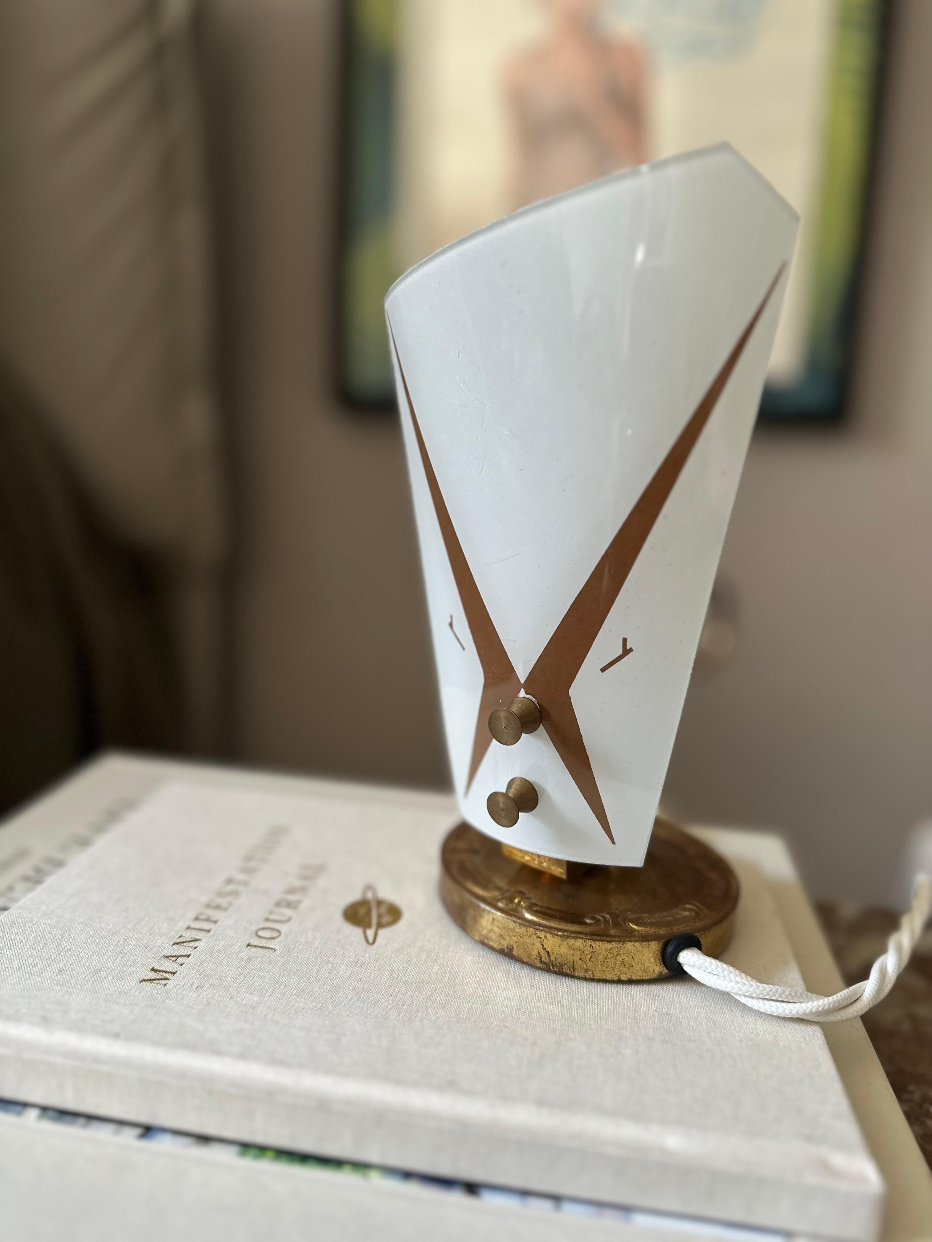 Cette charmante lampe de table italienne du milieu du siècle capture l'élégance et la légèreté du Design/One des années 1950, combinant une silhouette romantique avec une form A fonctionnelle. Fabriquée en métal avec une finition dorée chaleureuse,
