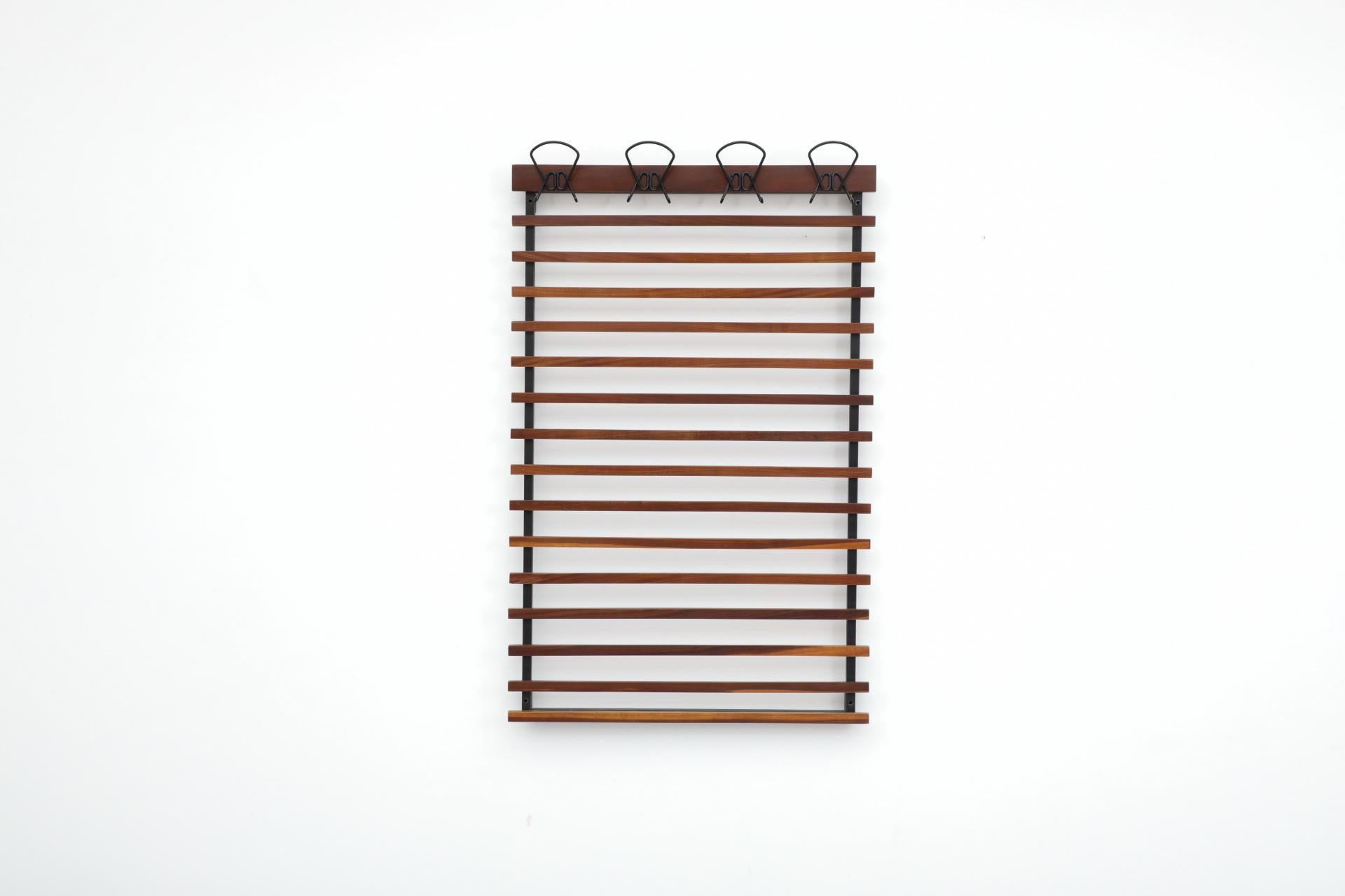 Appendiabiti a muro a doghe orizzontali in teak italiano del metà secolo con 4 grandi ganci per cappelli e cappotti in filo metallico smaltato nero. In condizioni originali con usura visibile. L'usura è coerente con l'età e l'uso. Sono disponibili