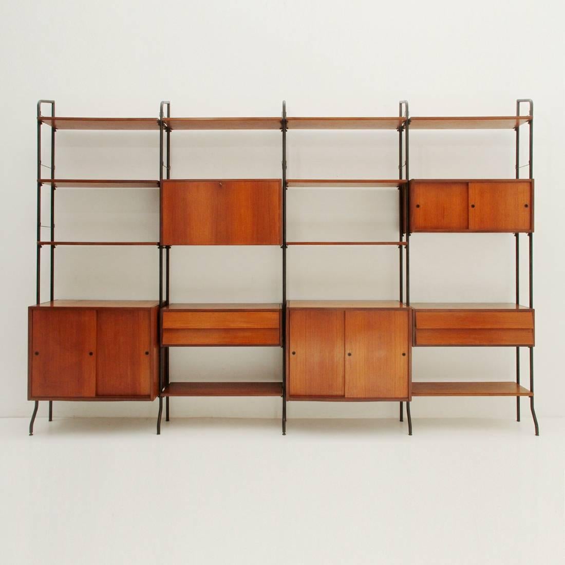 Large wall unit produced by Amma di Torino in the 1950s.
Uprights in black painted folded metal tubing.
Adjustable brass feet.
Containers, drawers and shelves in veneered teak wood.
Brass screws.
Good general conditions, some signs due to